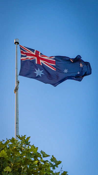 Australian flag waving against a clear blue sky.