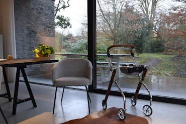 A walker and chair by a large window