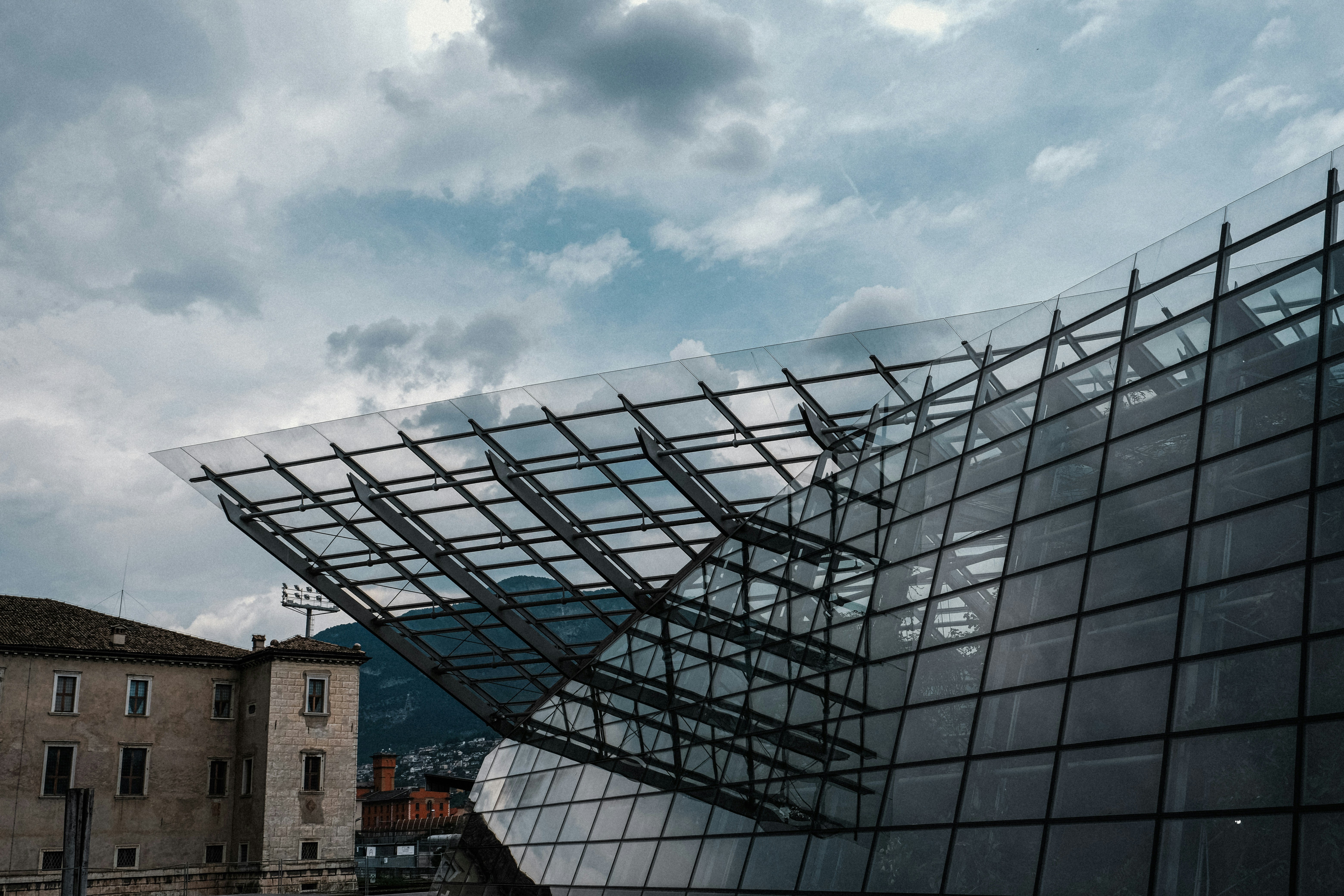 Modern glass building with mountains in background