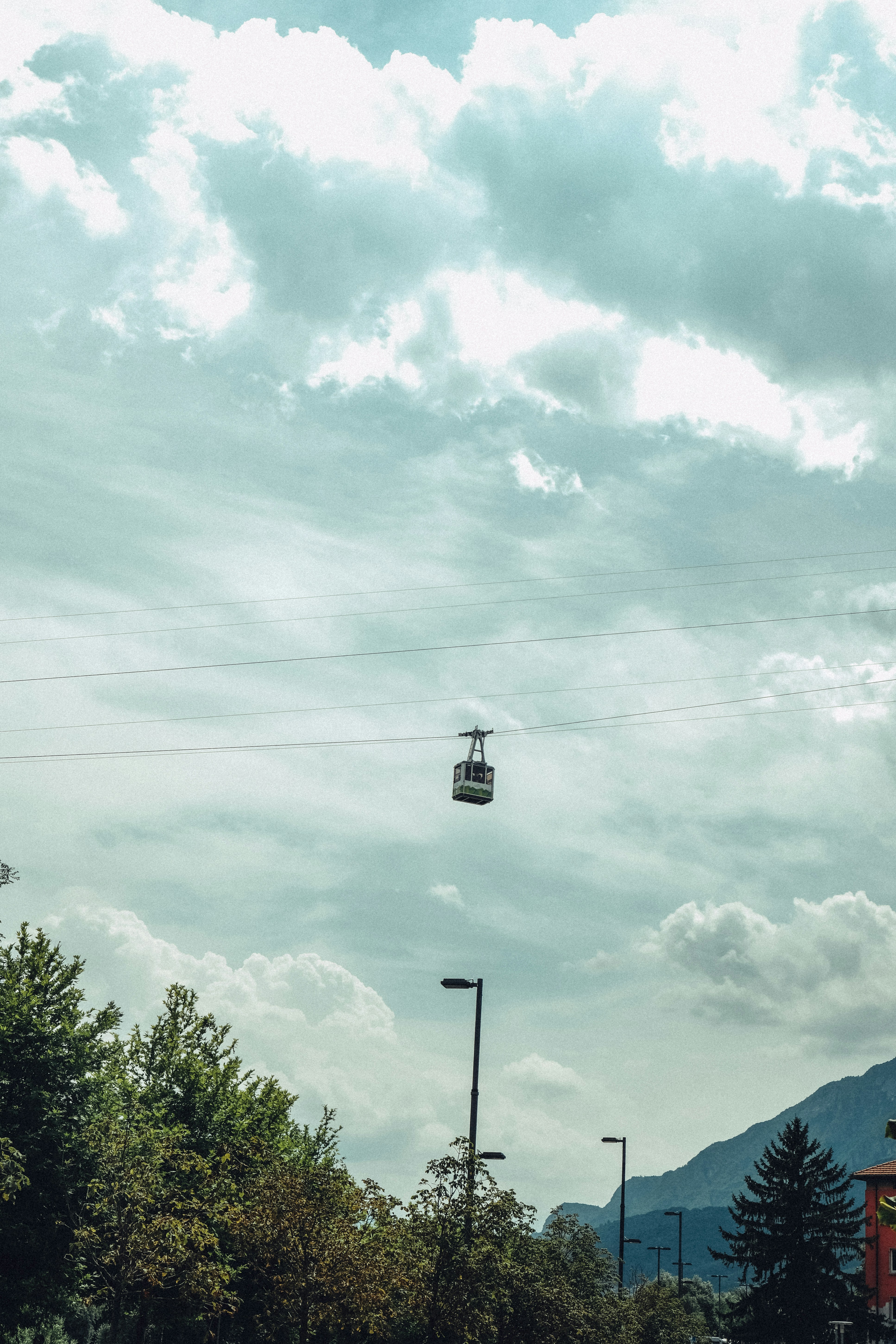 A cable car travels across a cloudy sky.