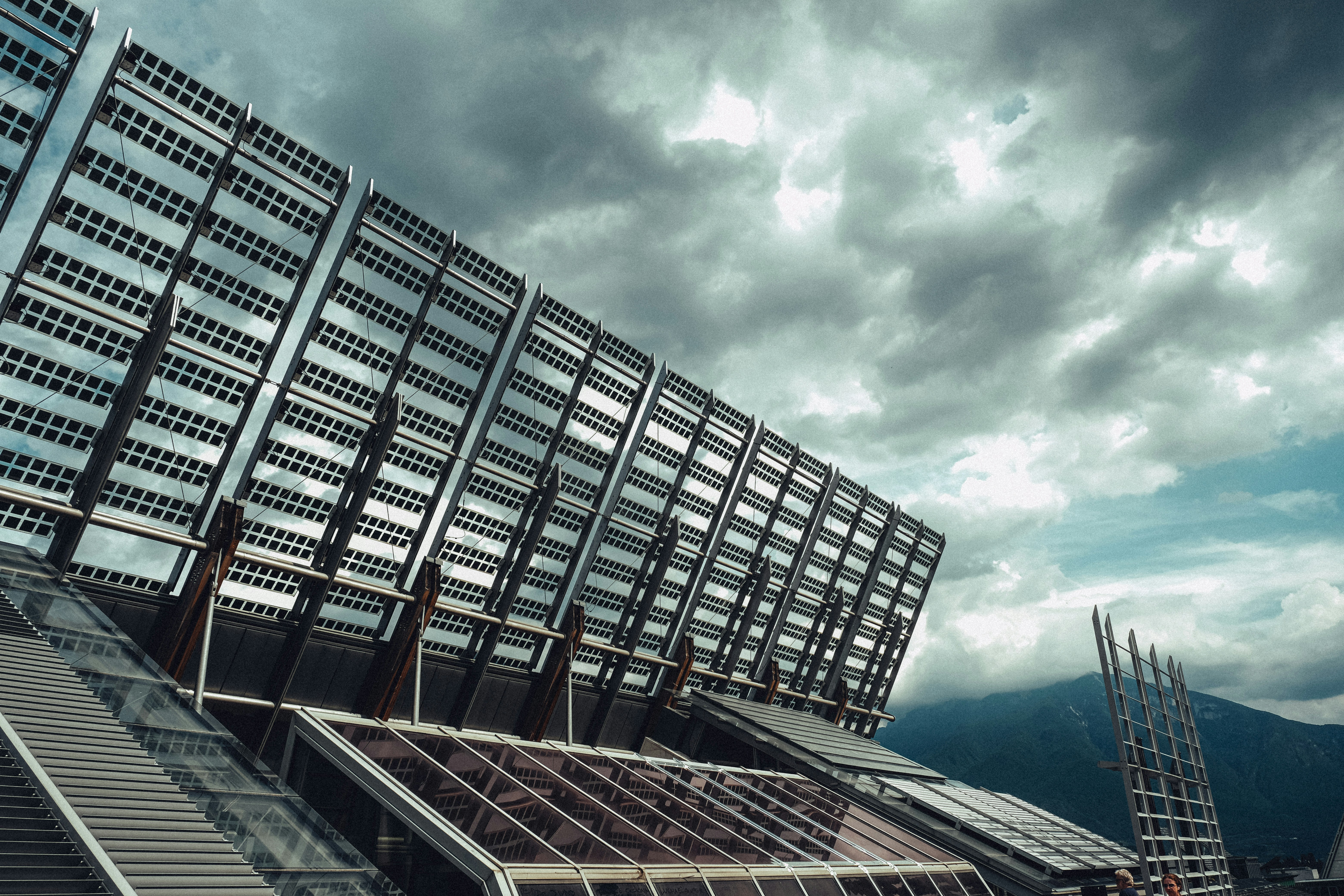 Modern building with large solar panels under cloudy sky