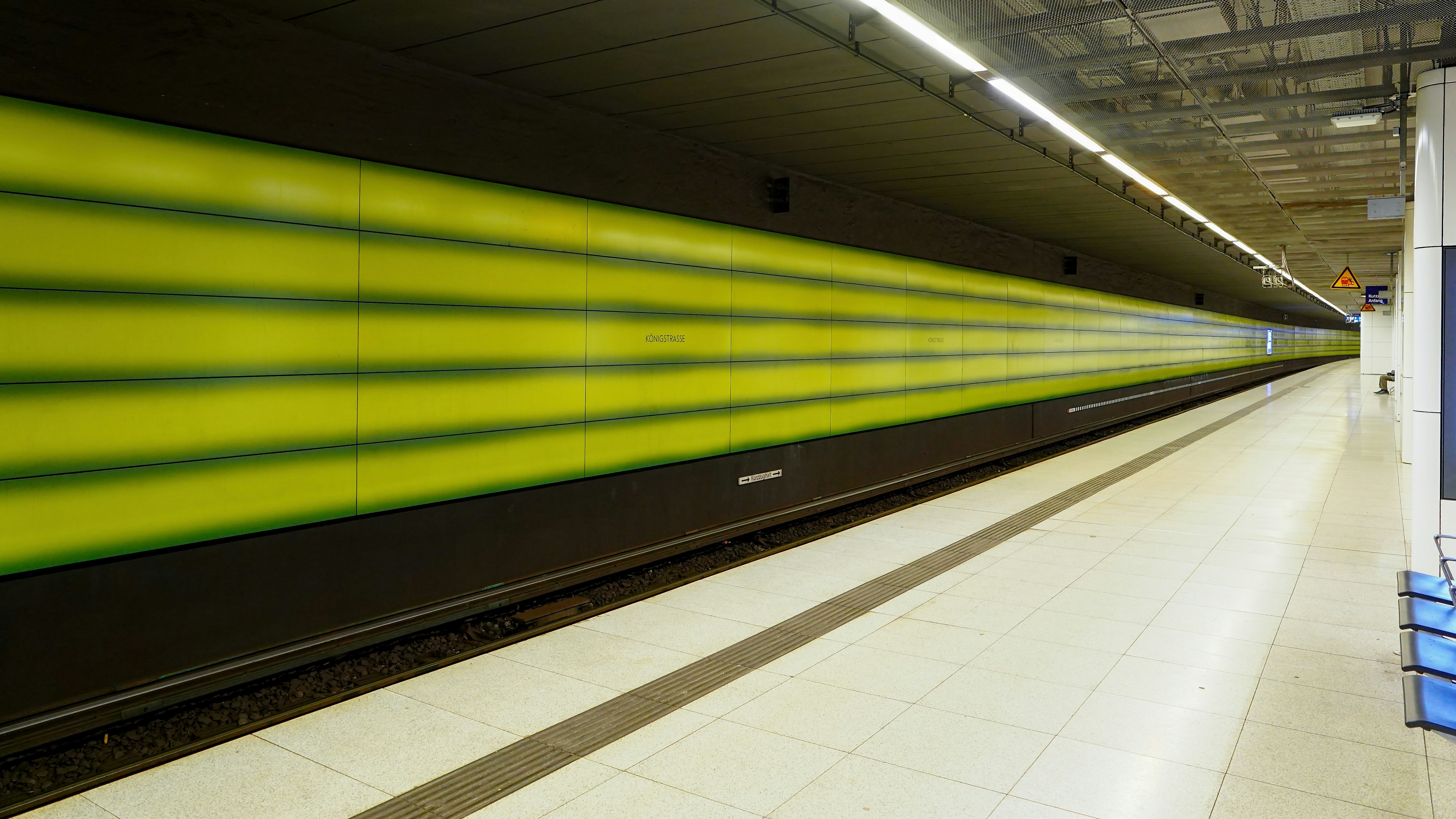 Modern subway station with yellow and green striped wall