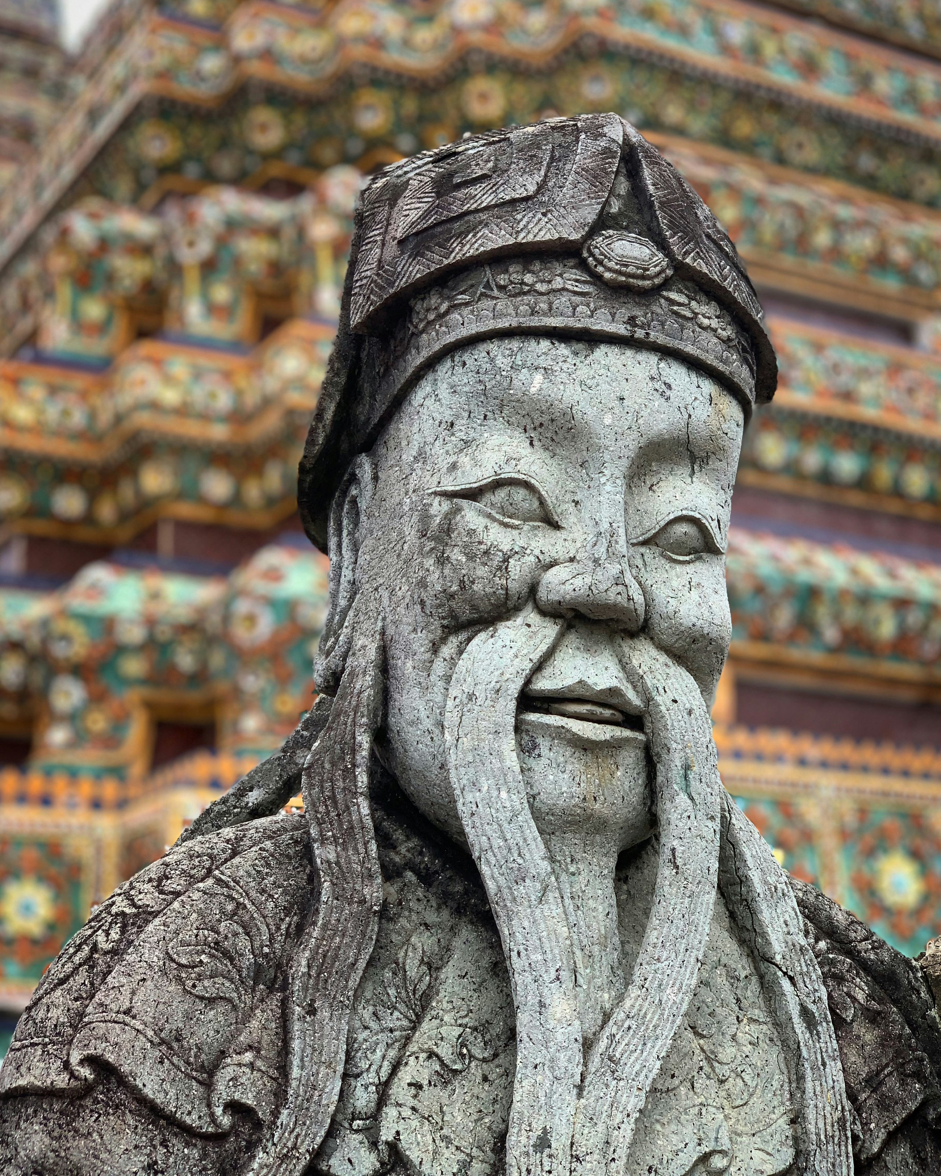 Steinstatue eines älteren Mannes mit langem Bart.