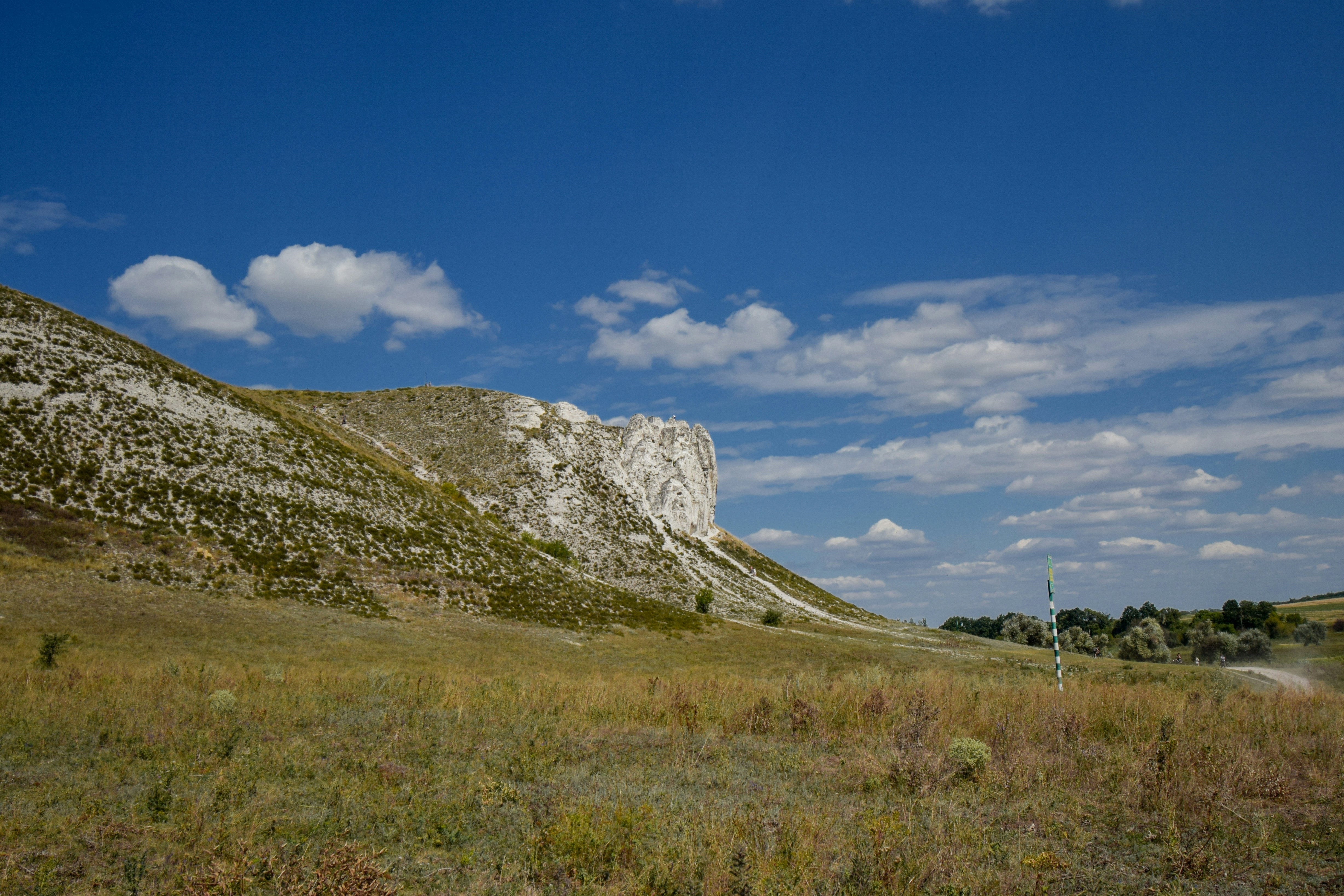 Face branca de penhasco sob um céu azul com nuvens
