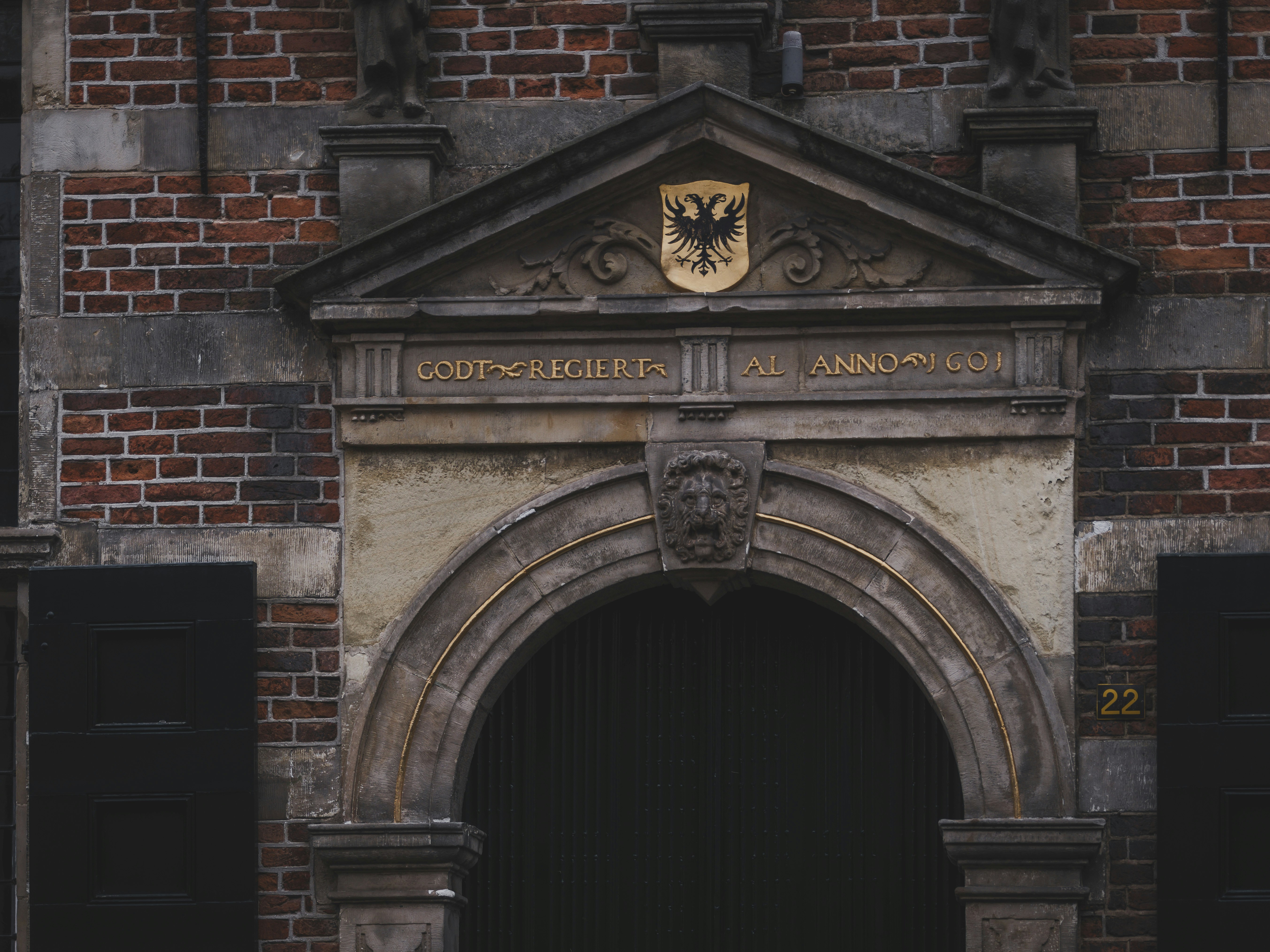 Arco in pietra ornato con stemma sopra l'ingresso.