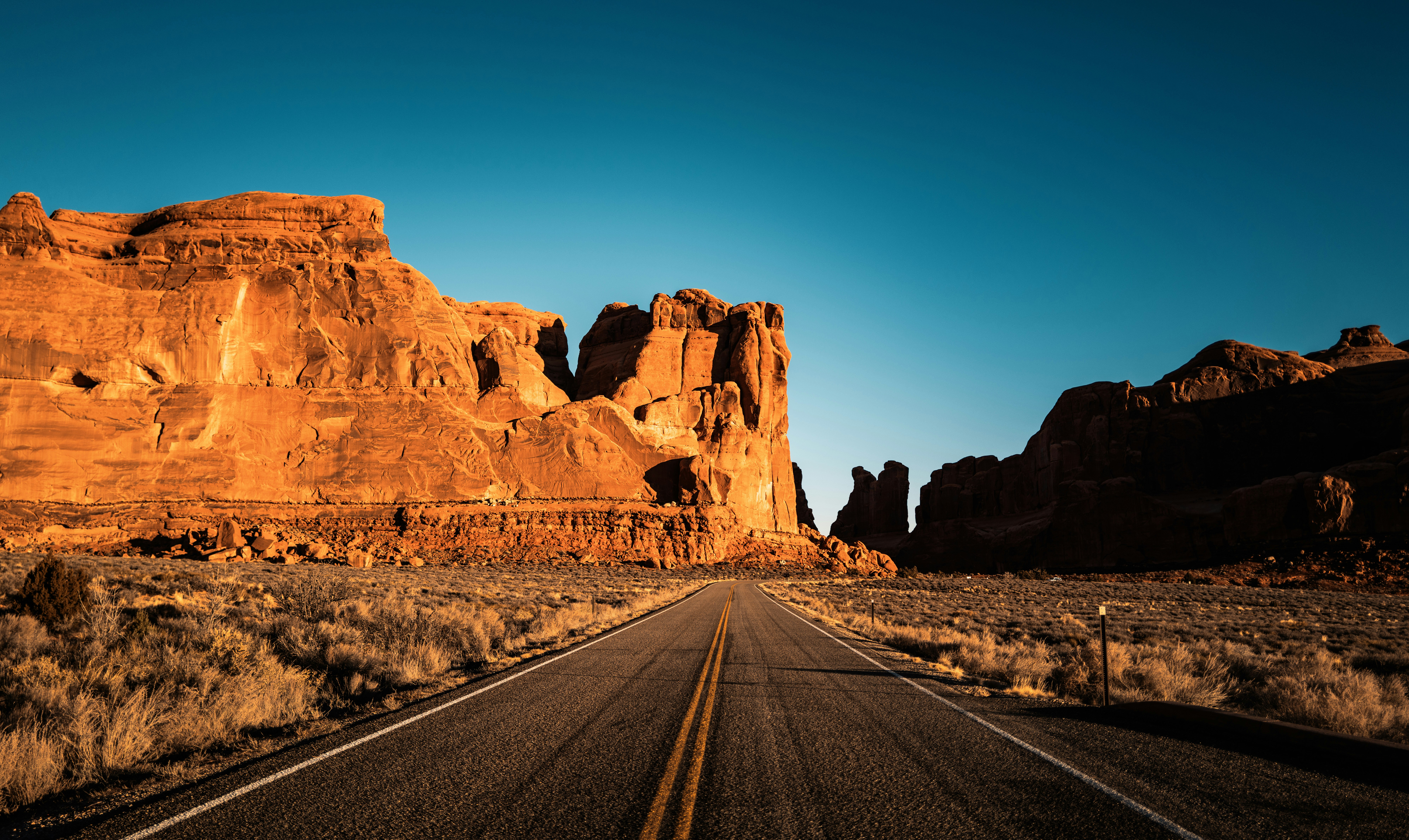 Desert road leading through sandstone rock formations