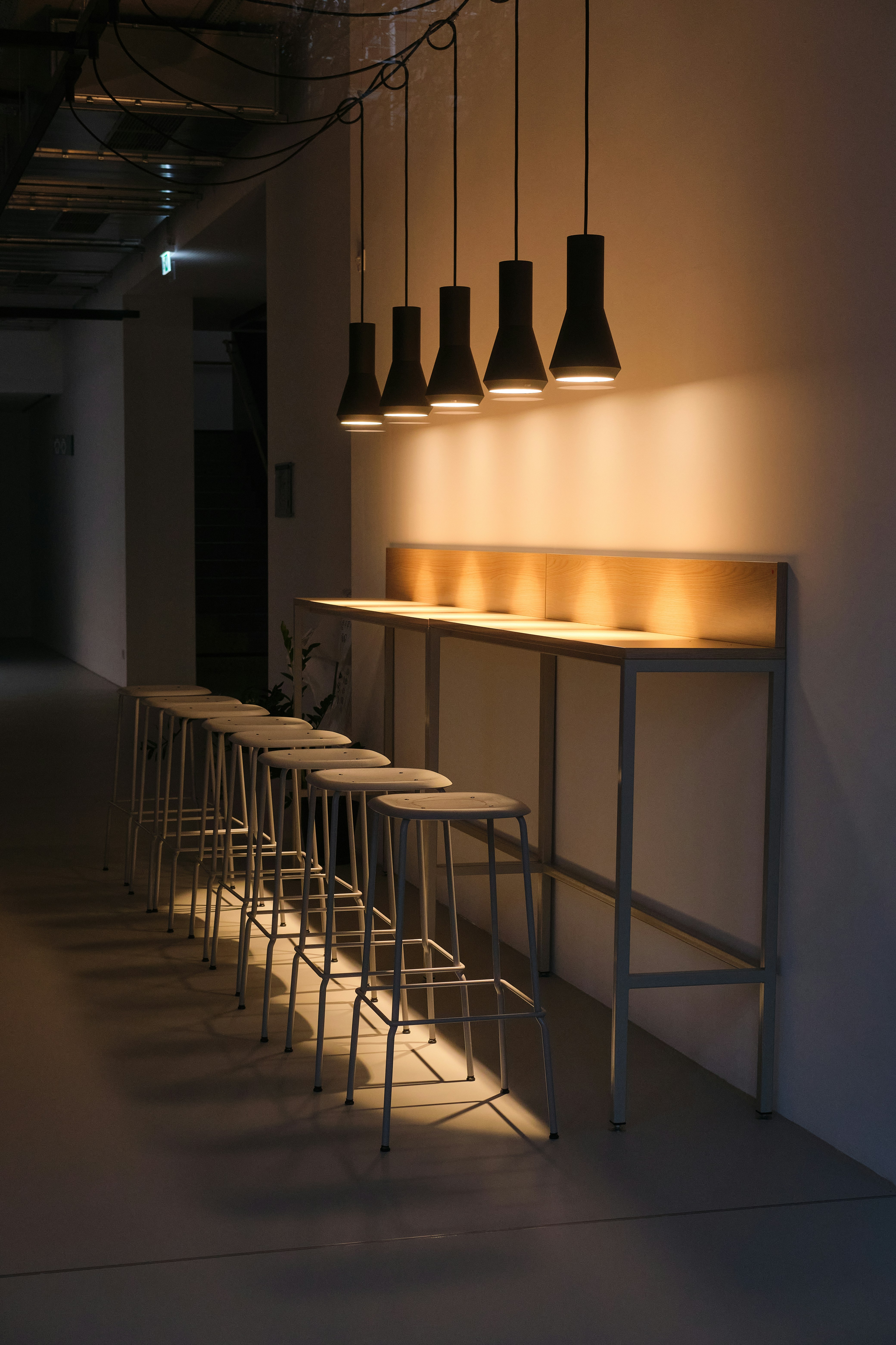 Bar stools lined up under pendant lights