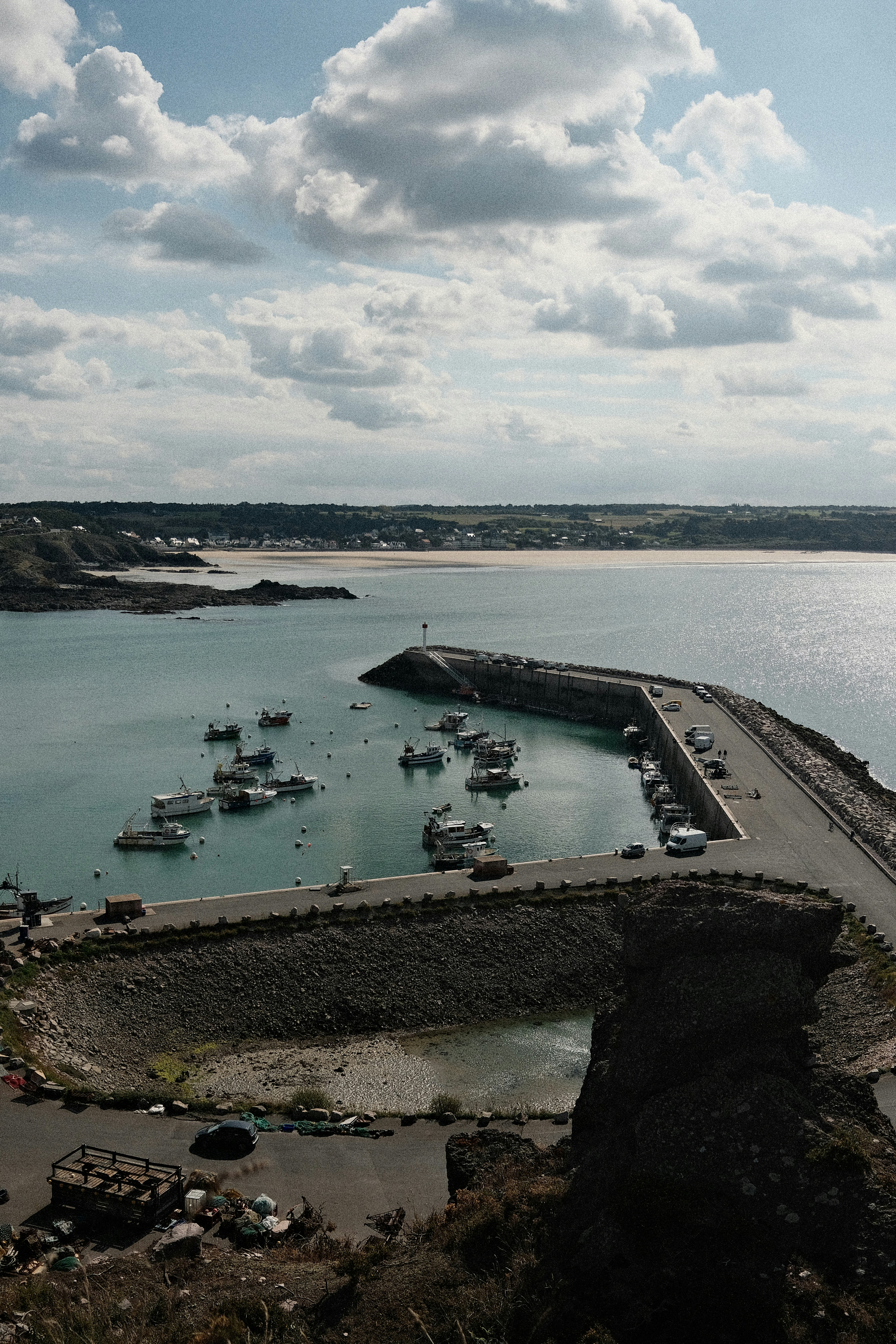 Boote lagen in einem Hafen mit einem langen Steinsteg.