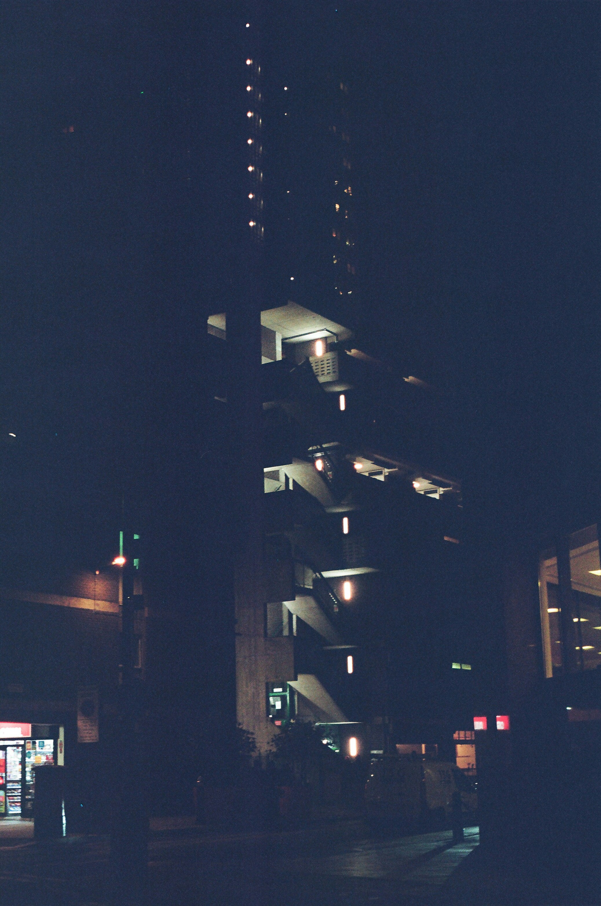 Tall building with illuminated stairs at night