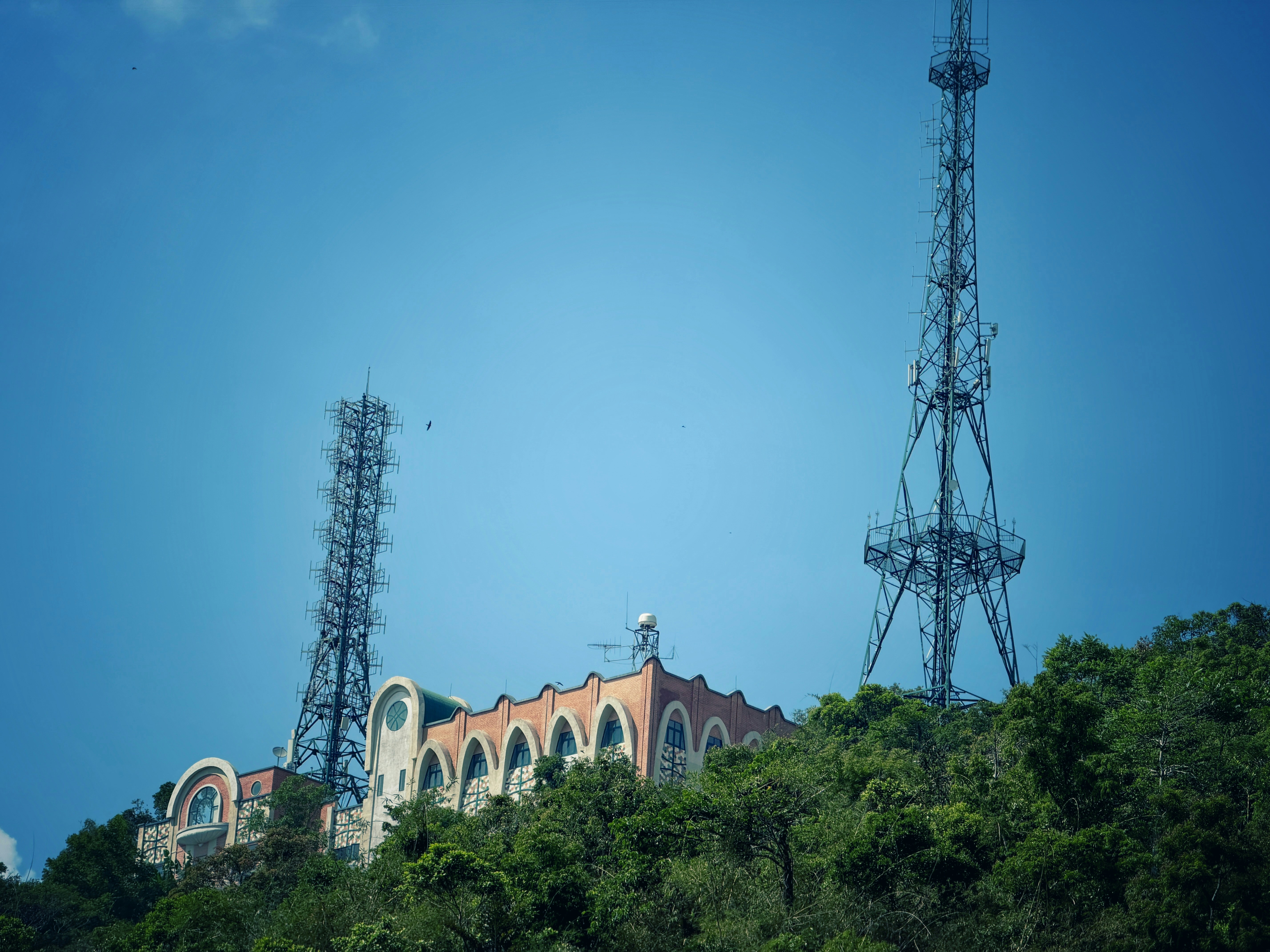 Dos torres se elevan sobre un edificio en una colina.