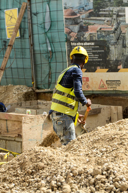 Construction worker digging with a shovel in dirt.