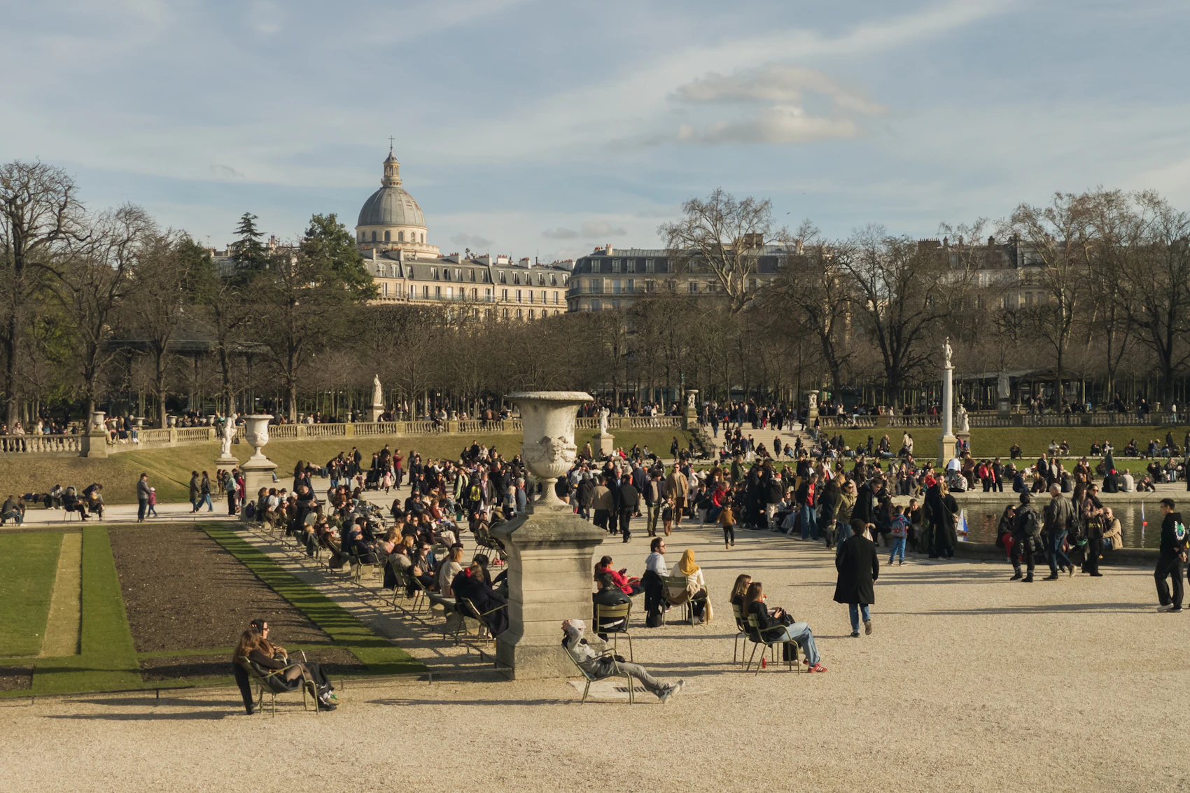 People relaxing on the lawns of Luxembourg Gardens in Paris in spring