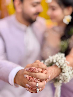 Couple holding hands with intricate henna designs