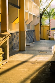 Sunlight streams across a construction site with building materials.