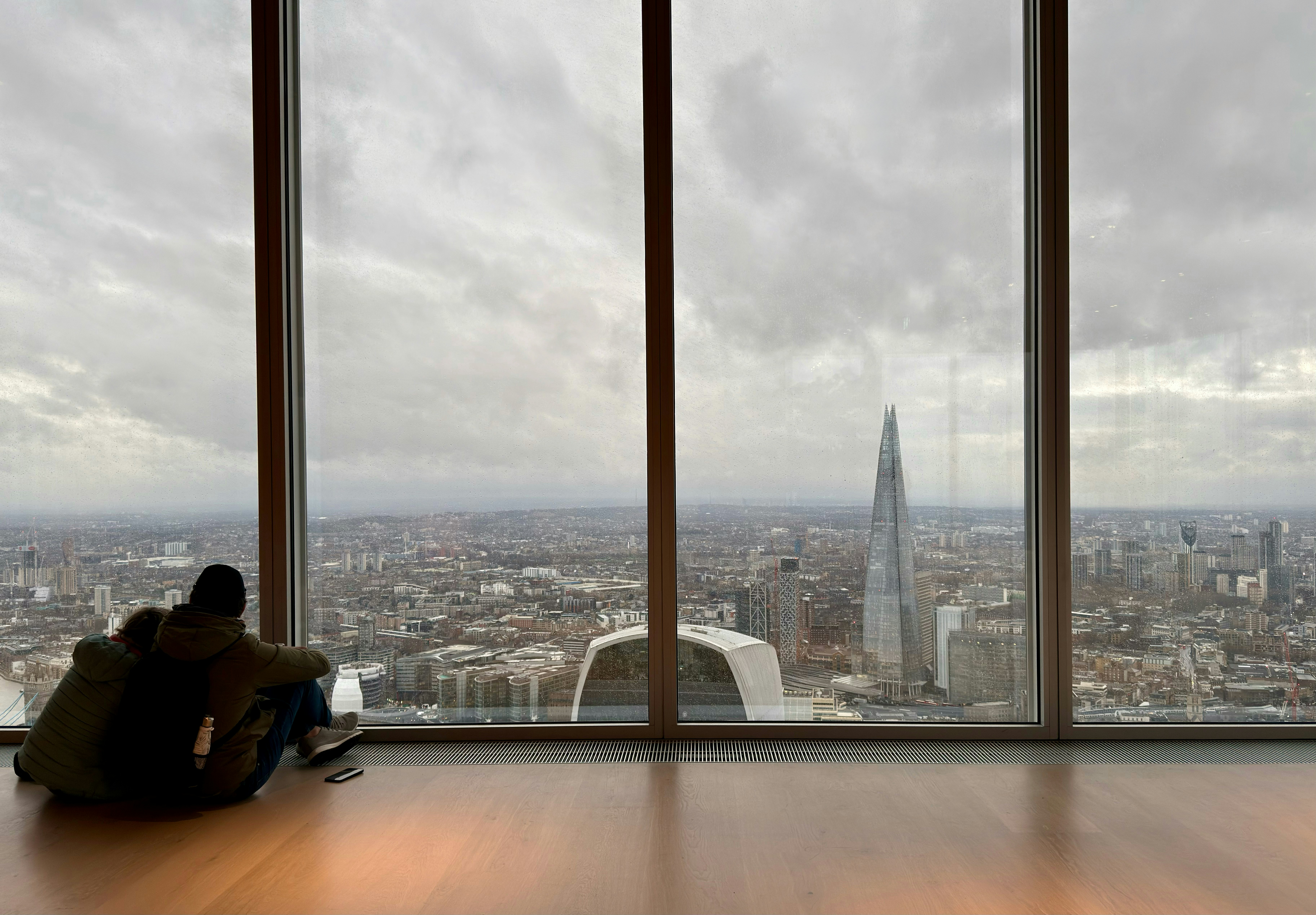 Couple looking out at a cloudy city skyline