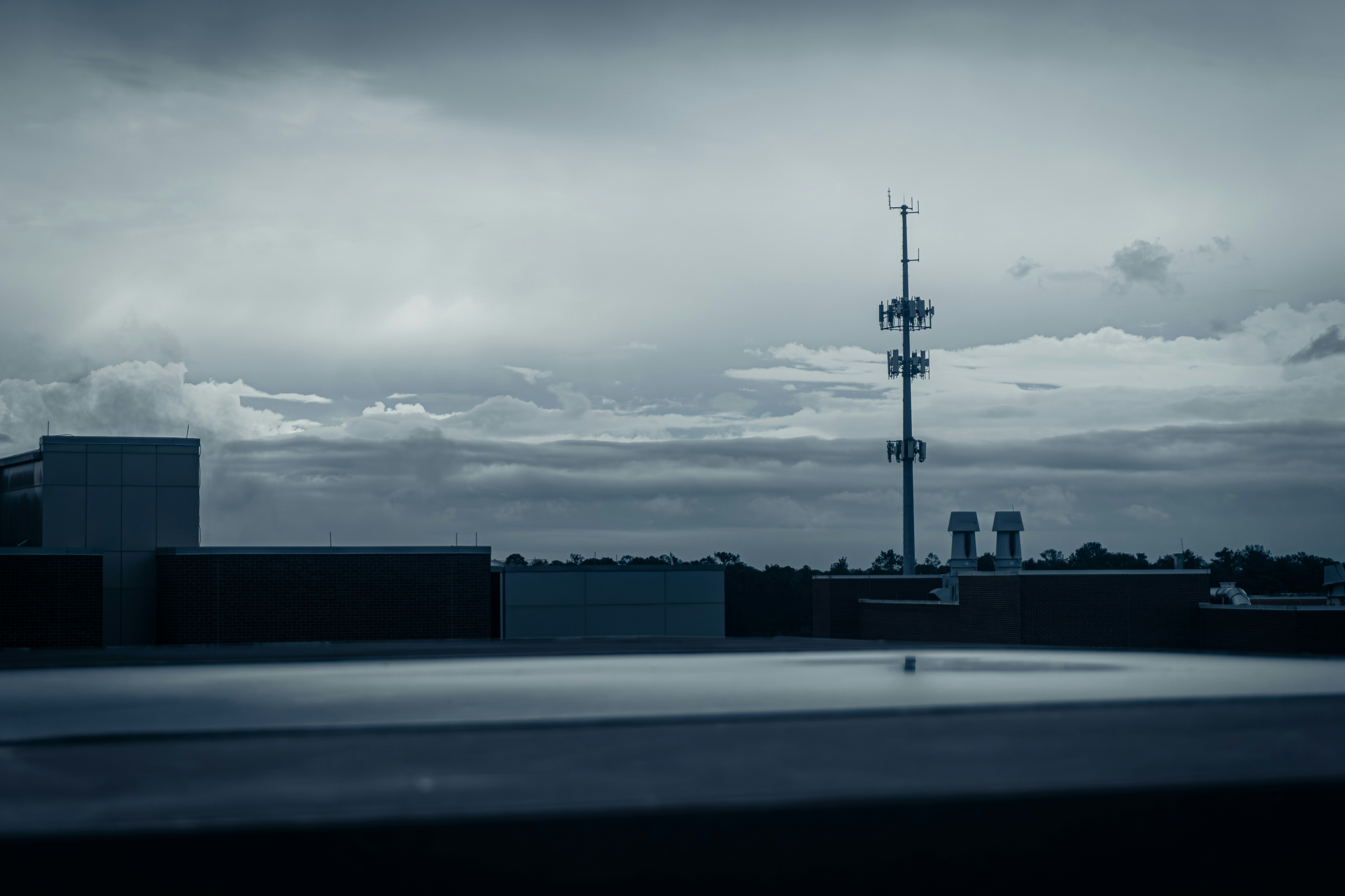 Rooftop view with cell tower and cloudy sky