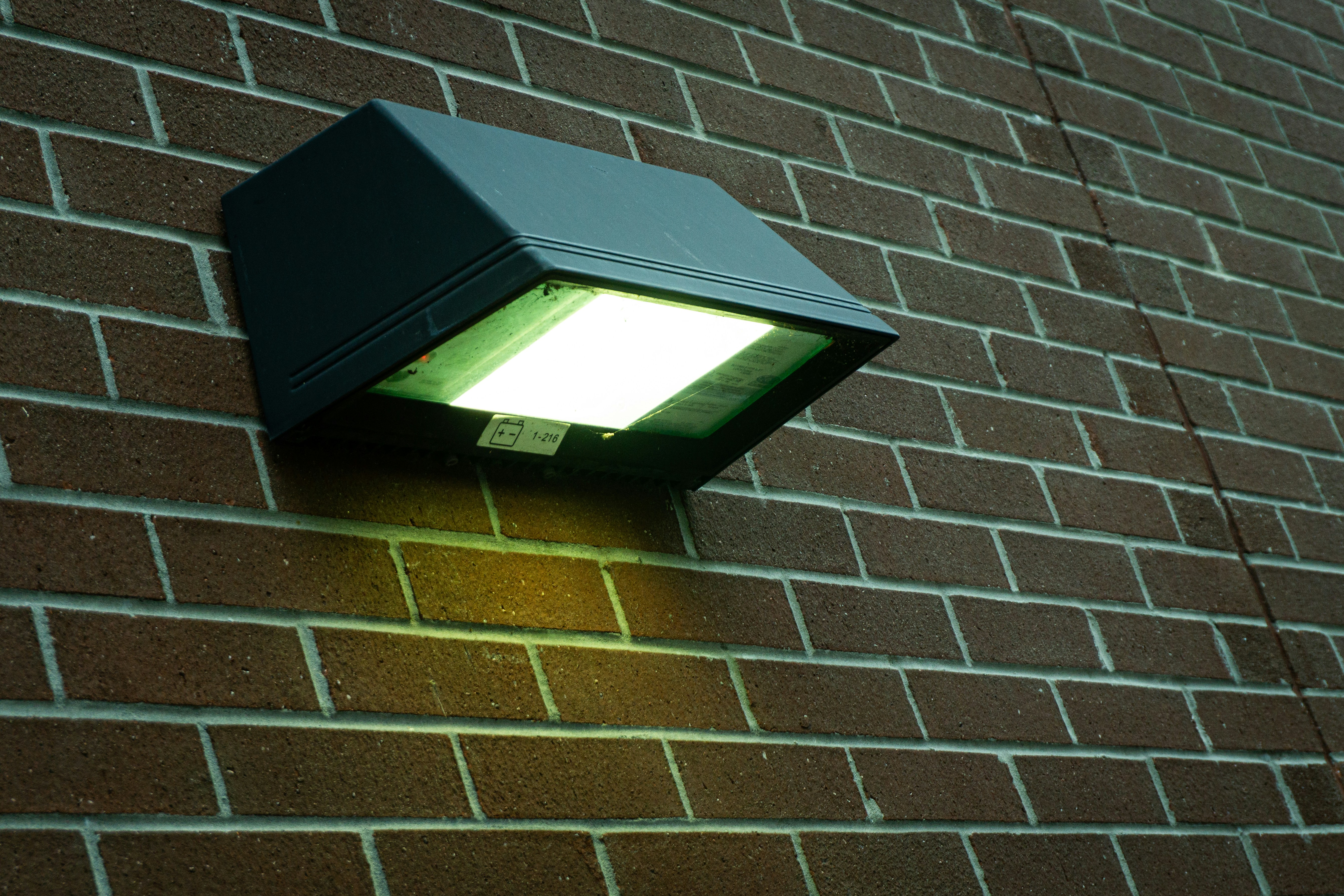 A modern outdoor light fixture on a brick wall.