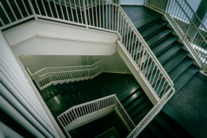 Modern staircase with white railings descends downwards.