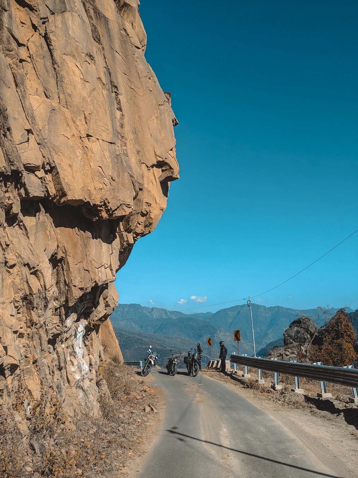 Riders on a cliffside mountain road