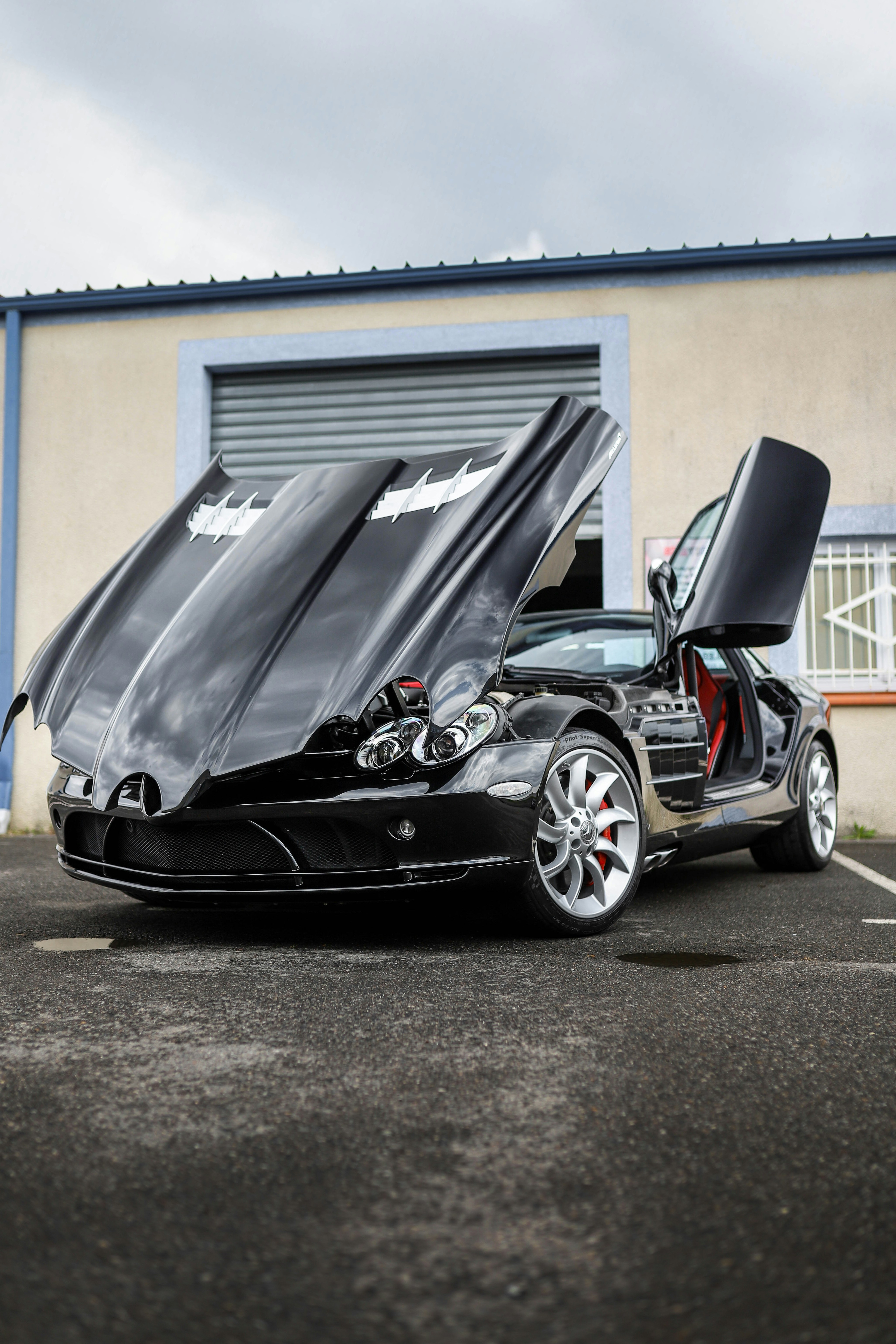 Black sports car with doors and hood open