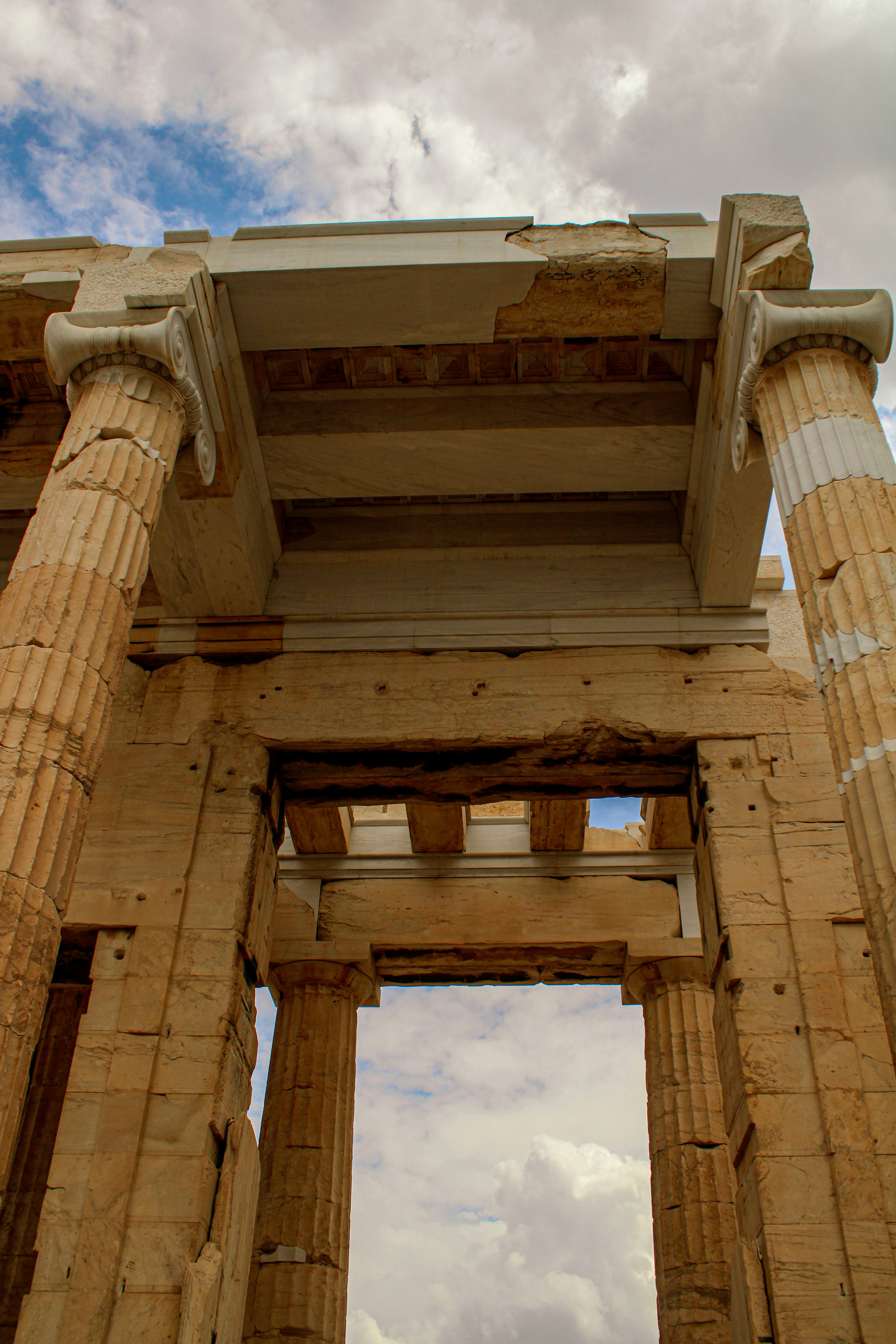 Ancient greek ruins with columns against a cloudy sky