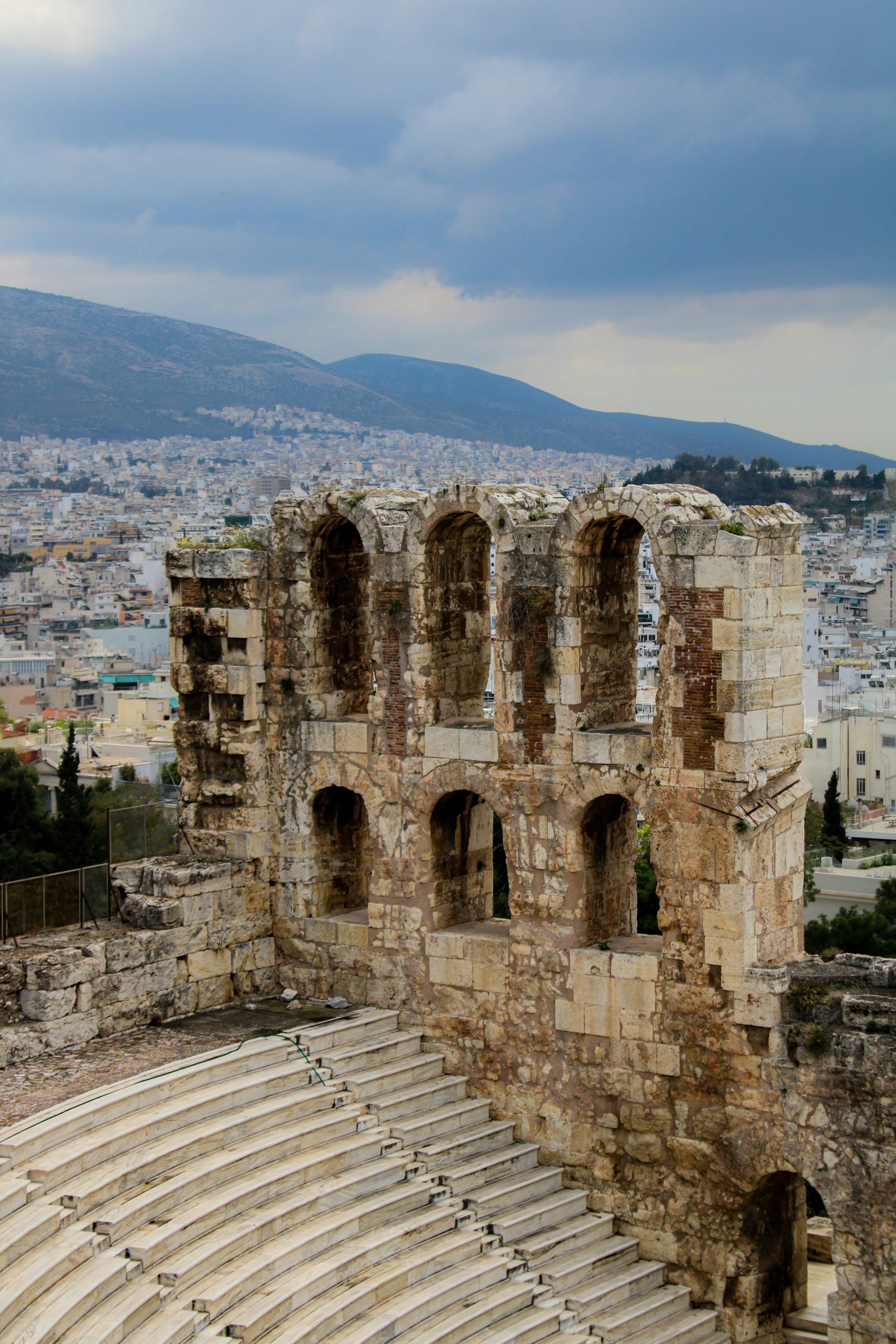 Ancient stone amphitheater ruins with city background