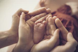 Parental hands cradle a newborn baby's tiny foot