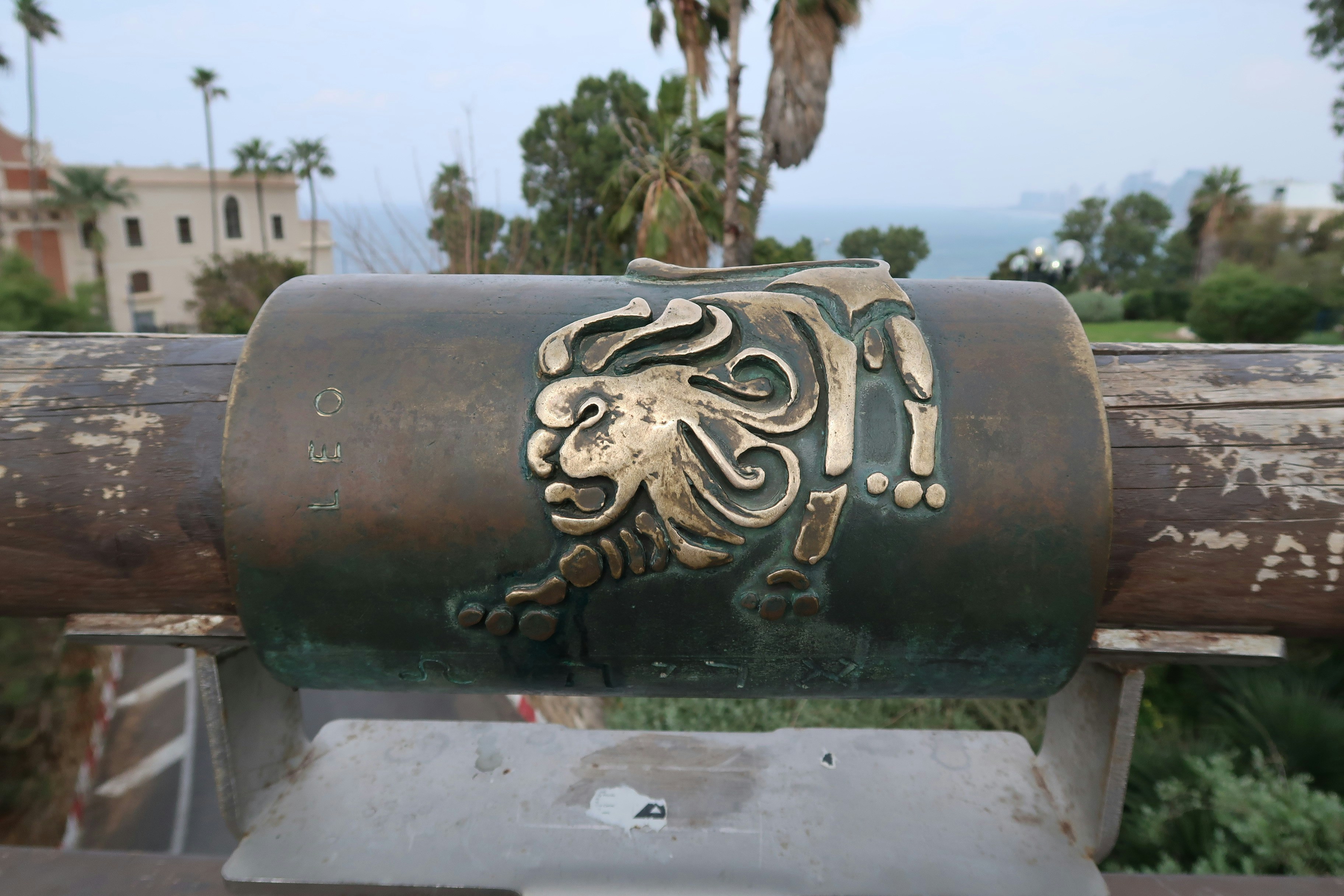 Bronze sculpture of a lion on a wooden railing