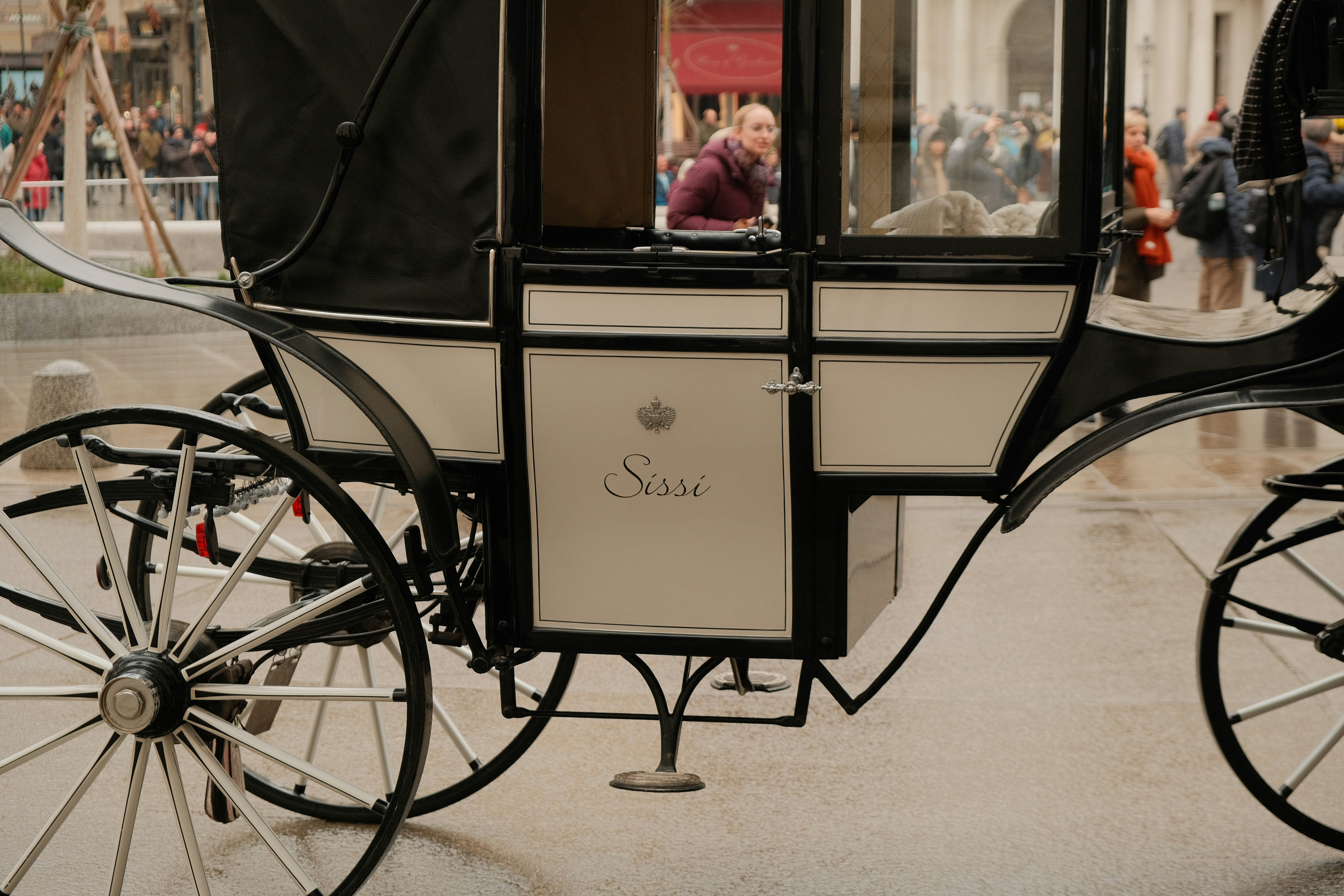 A white horse-drawn carriage with people in background.