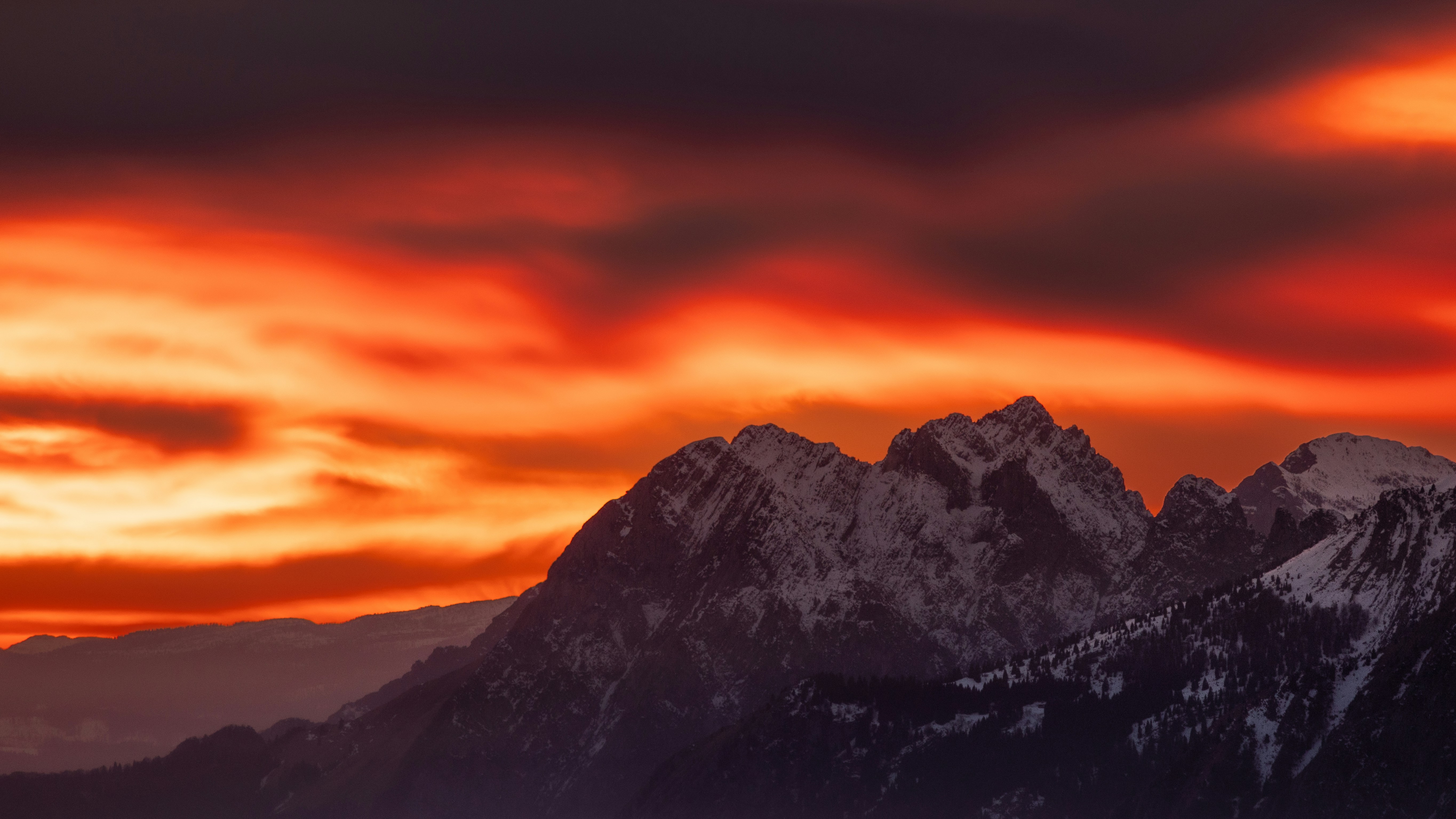 Fiery sunset over snow-capped mountains