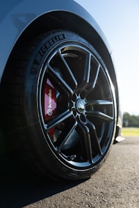 Pad and red Brembo caliper detail behind alloy wheel