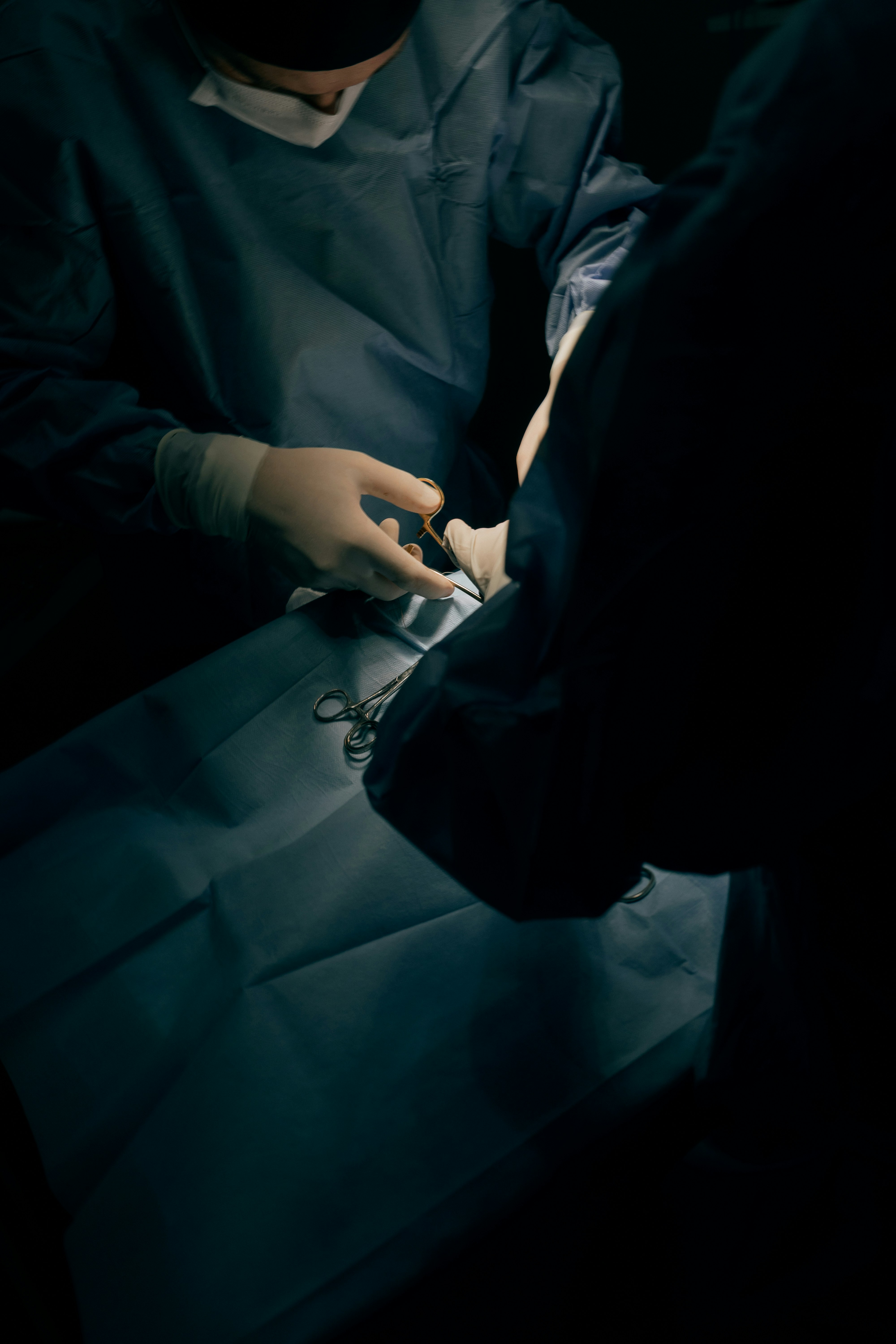 Surgeons performing a medical procedure in an operating room.