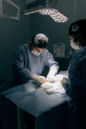 Surgeons performing a medical procedure under bright lights.