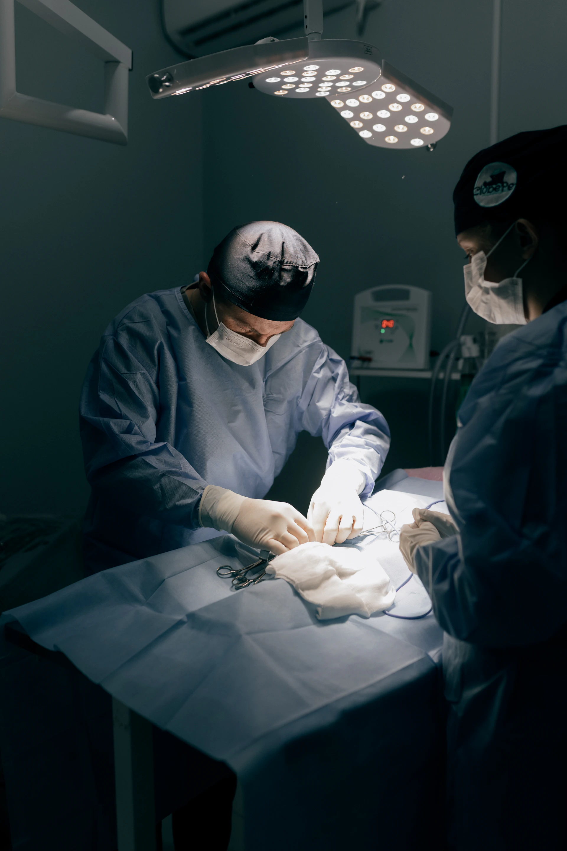 Surgeons performing a medical procedure under bright lights.