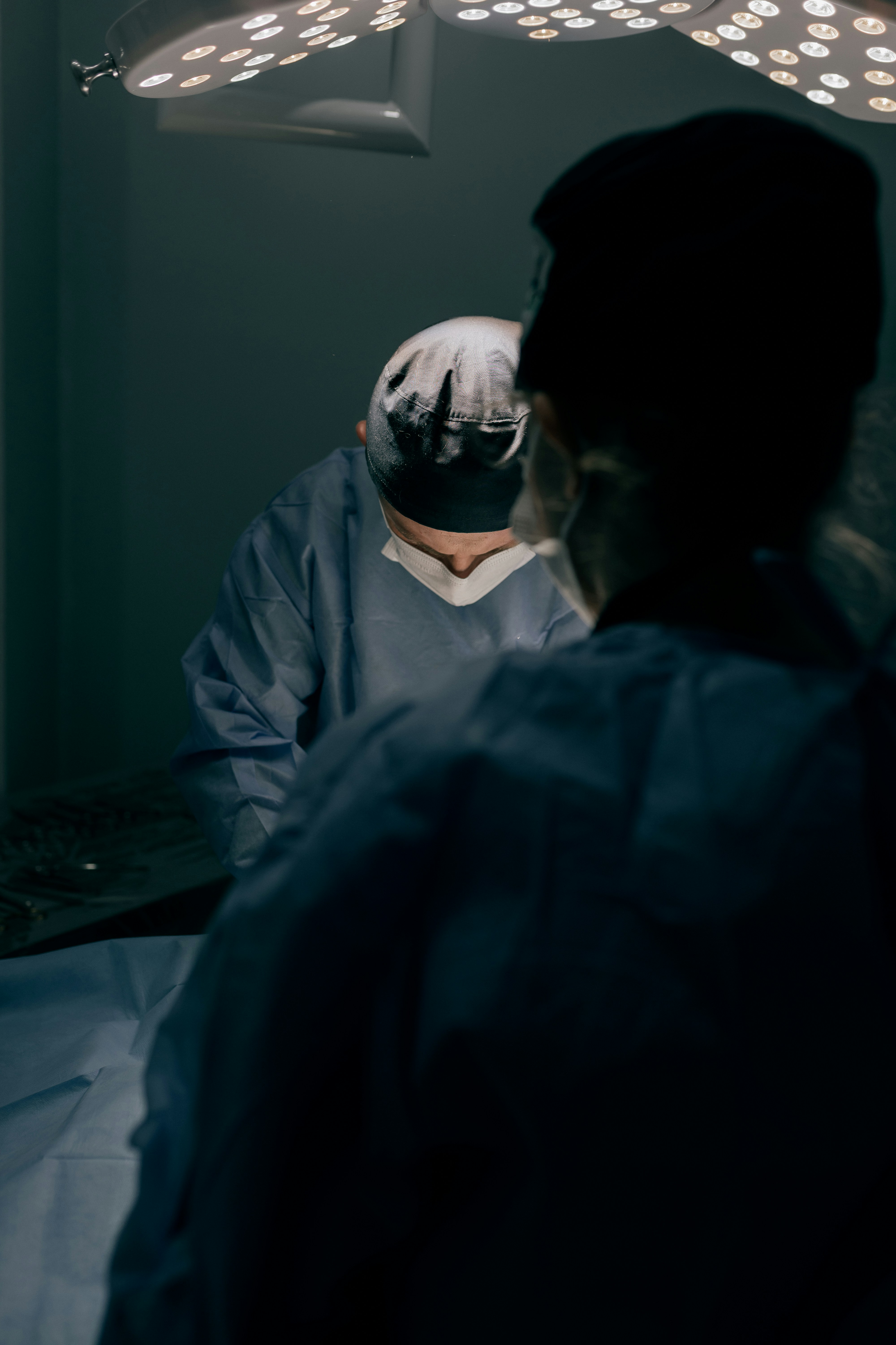 Surgeons operating under bright lights in a dark room