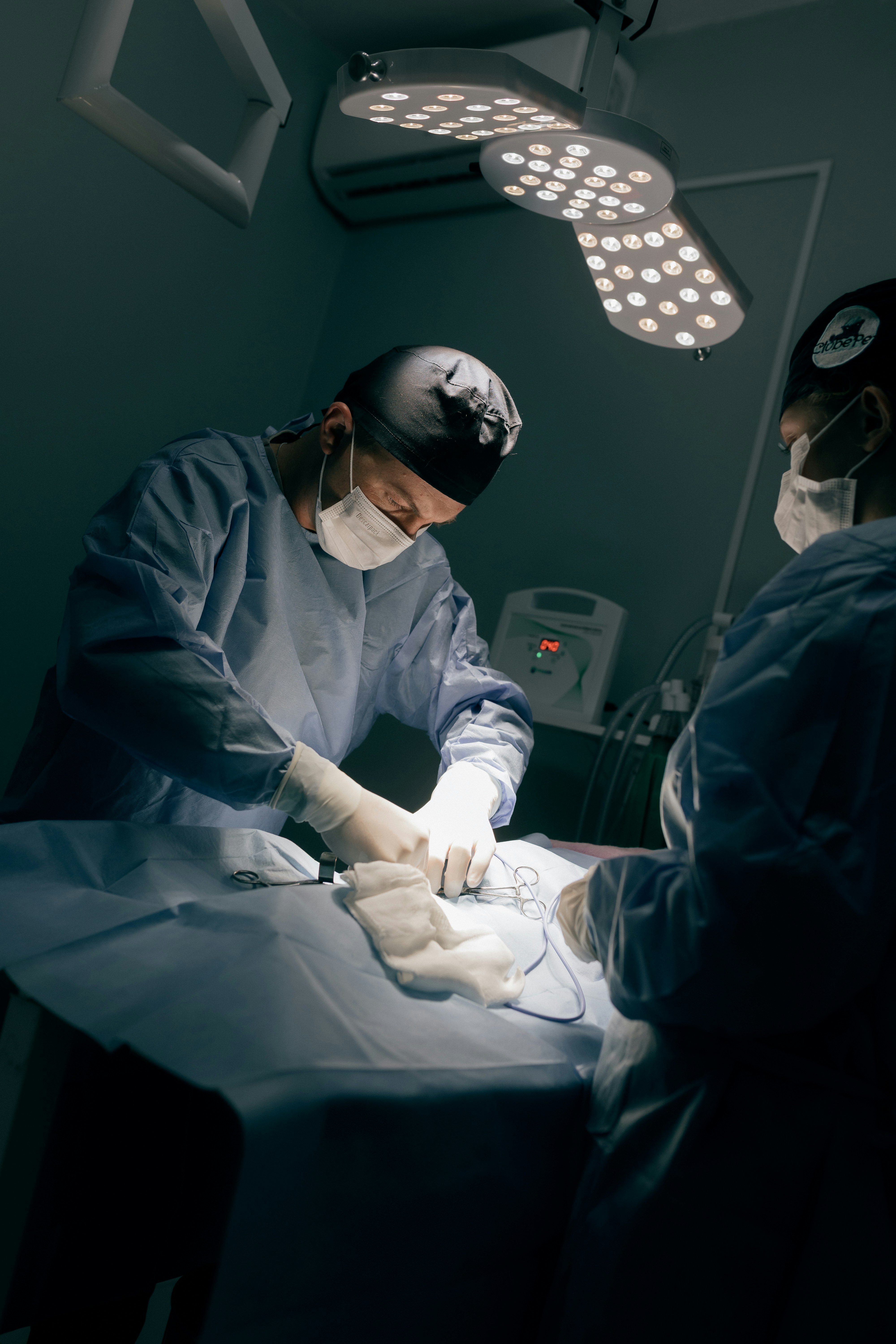 Surgeons performing a medical procedure under bright lights.