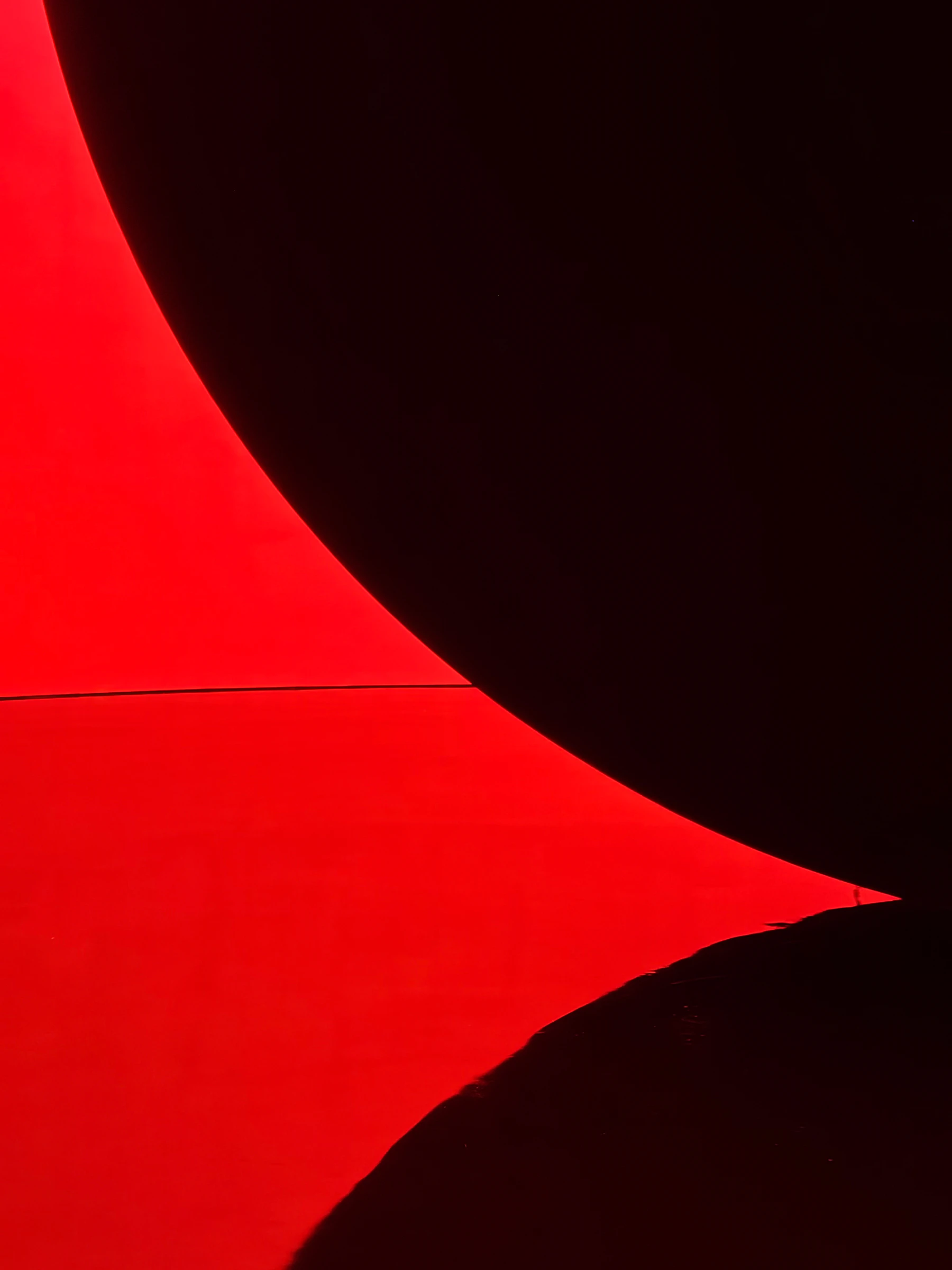 Abstract sculptural red and black forms in dramatic light