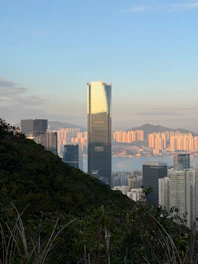 Modern skyscrapers rise above a city and harbor.