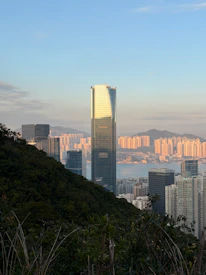 Modern skyscrapers rise above a city and harbor.