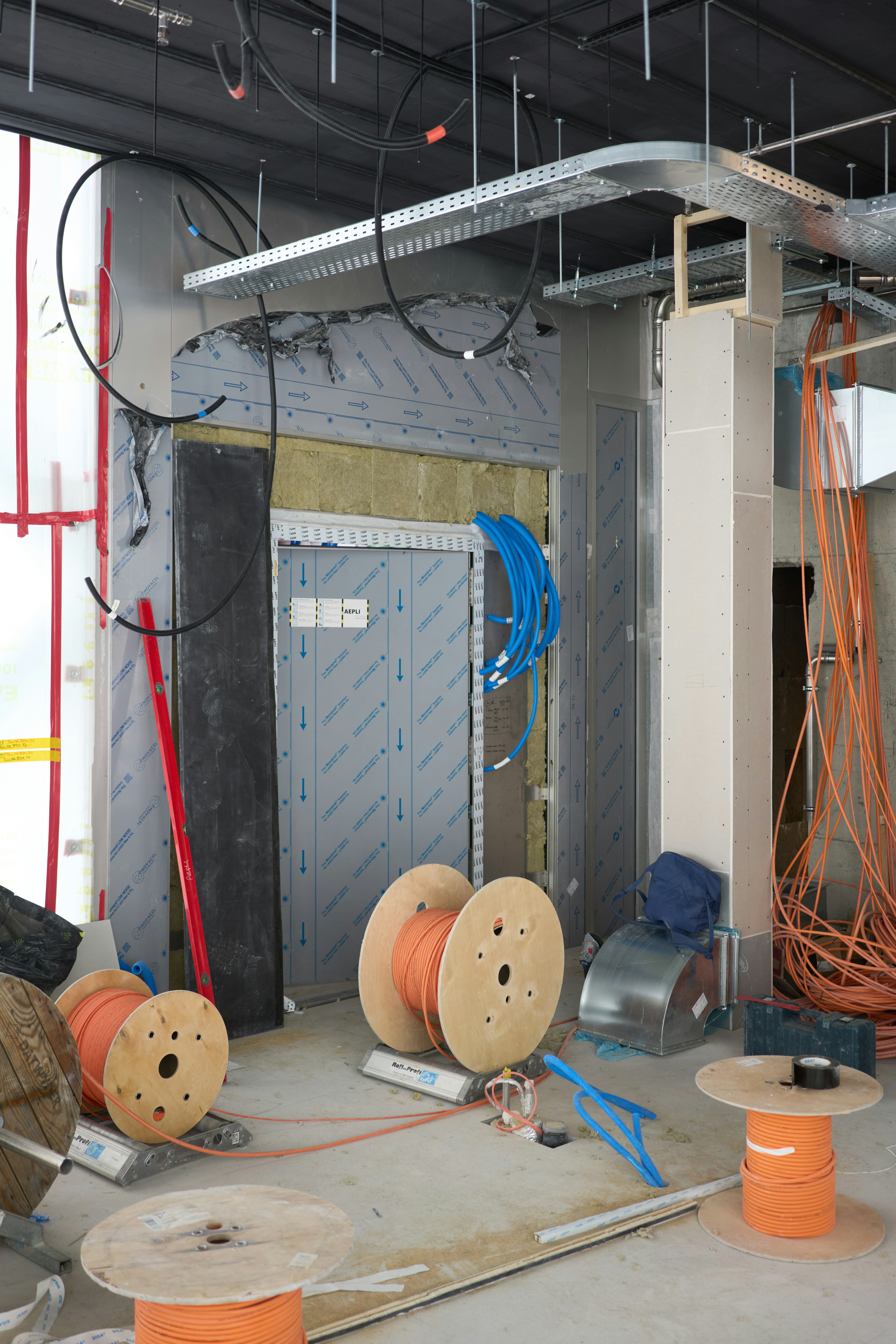 Construction site with electrical wiring and spools of cable.