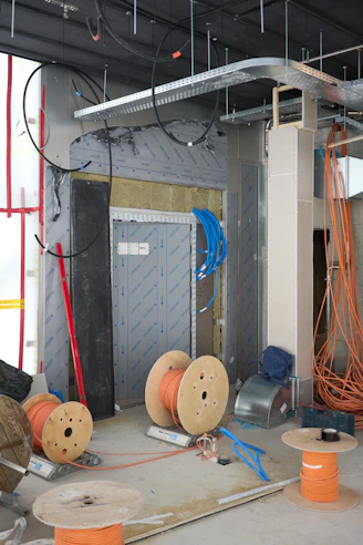Construction site with electrical wiring and spools of cable.