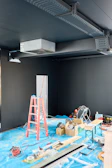 Interior construction site with tools and ladders.