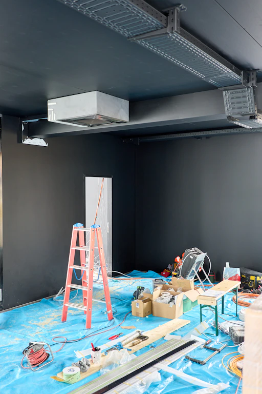 Interior construction site with tools and ladders.