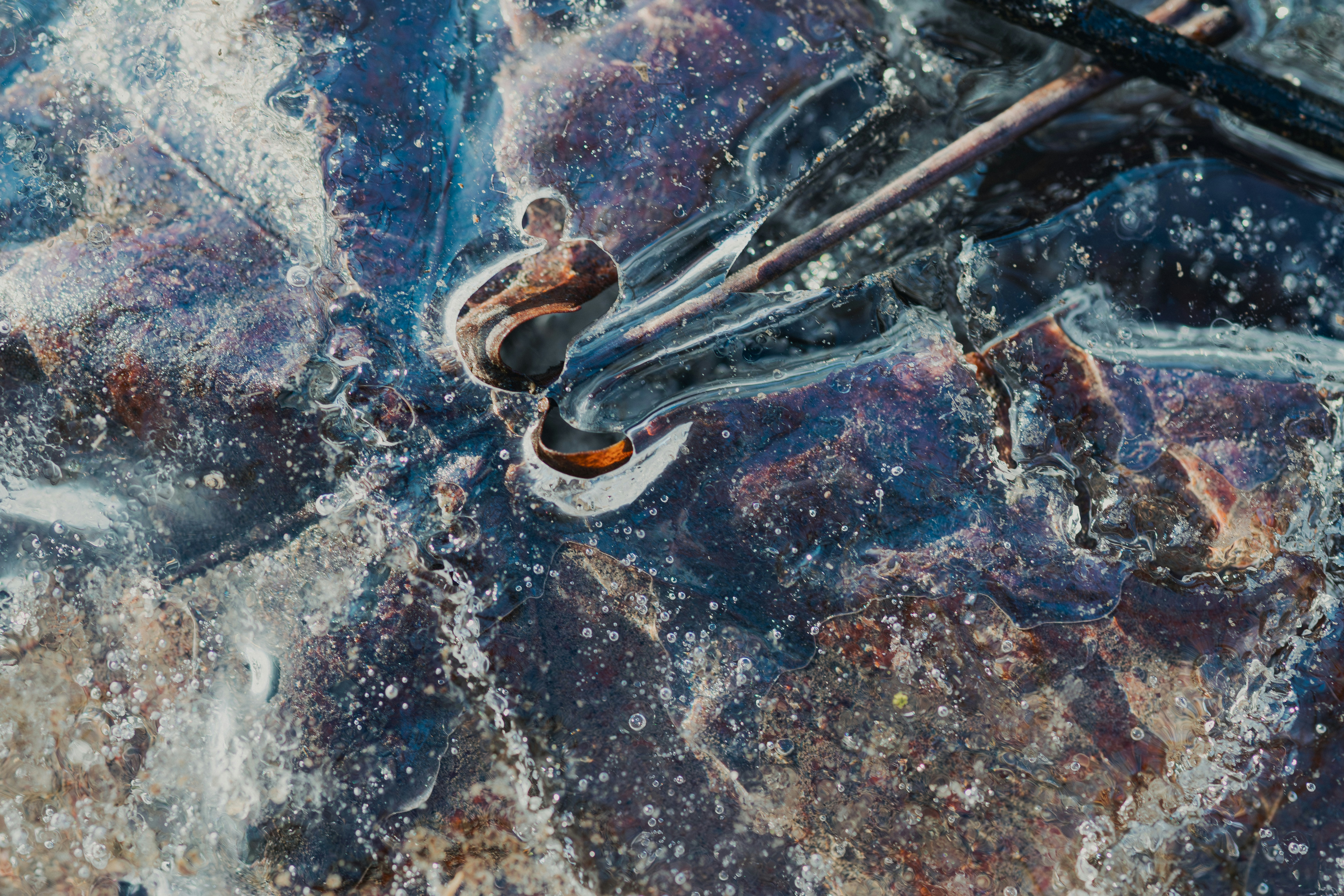 Close-up abstract of ice with colorful patterns and textures.