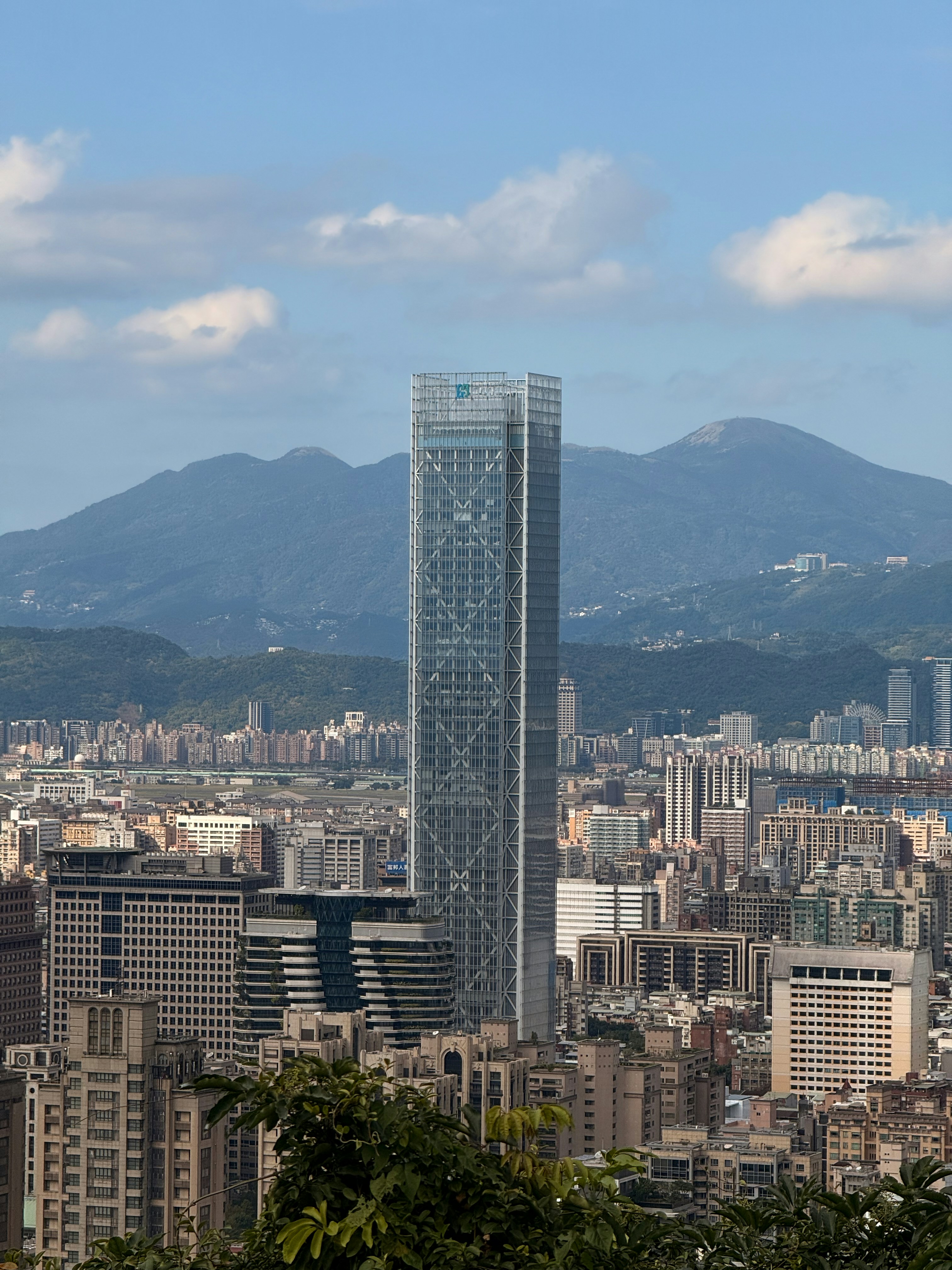 Modern skyscraper dominates a dense city skyline.