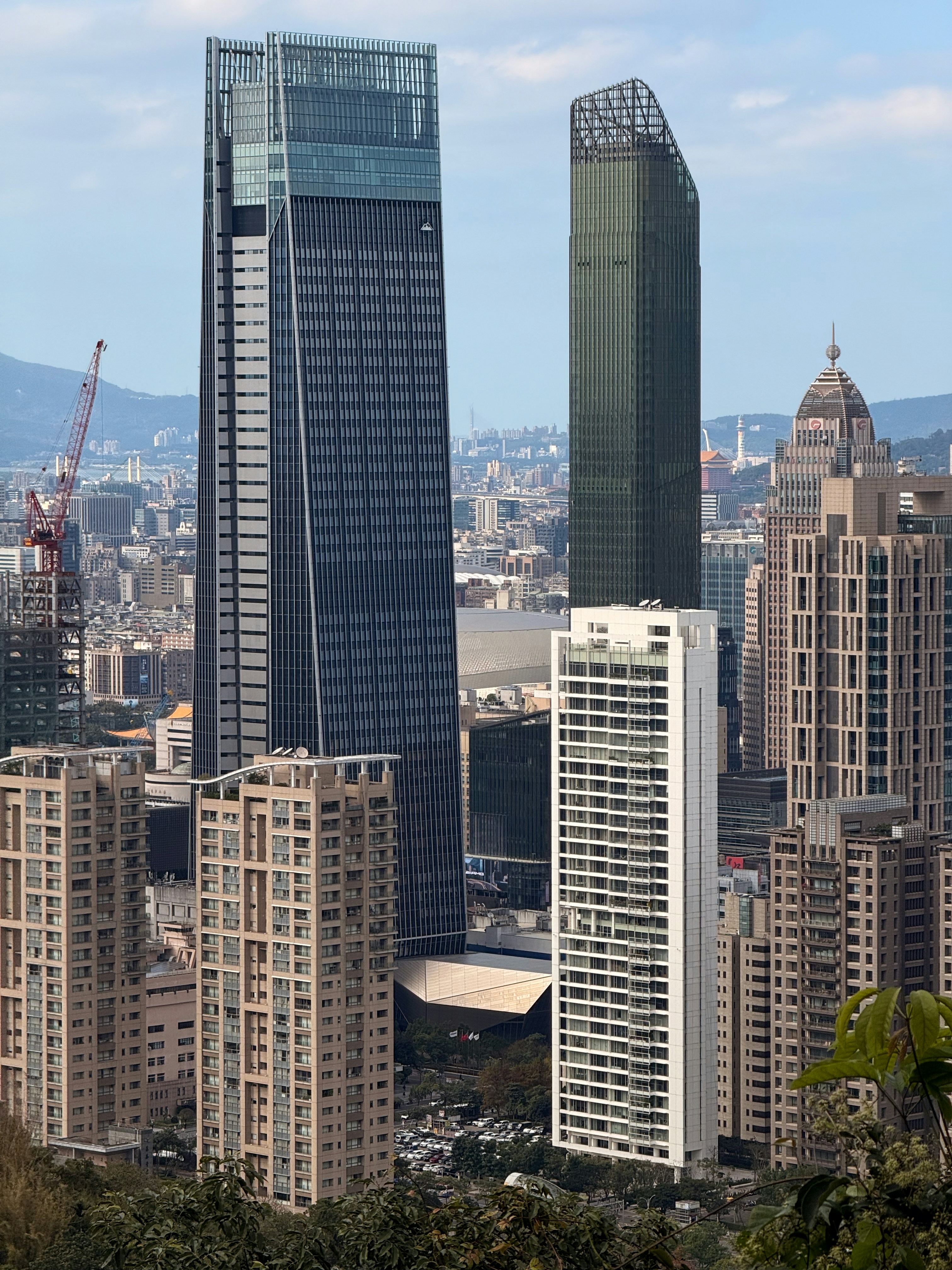 Modern skyscrapers dominate a city skyline under a clear sky.