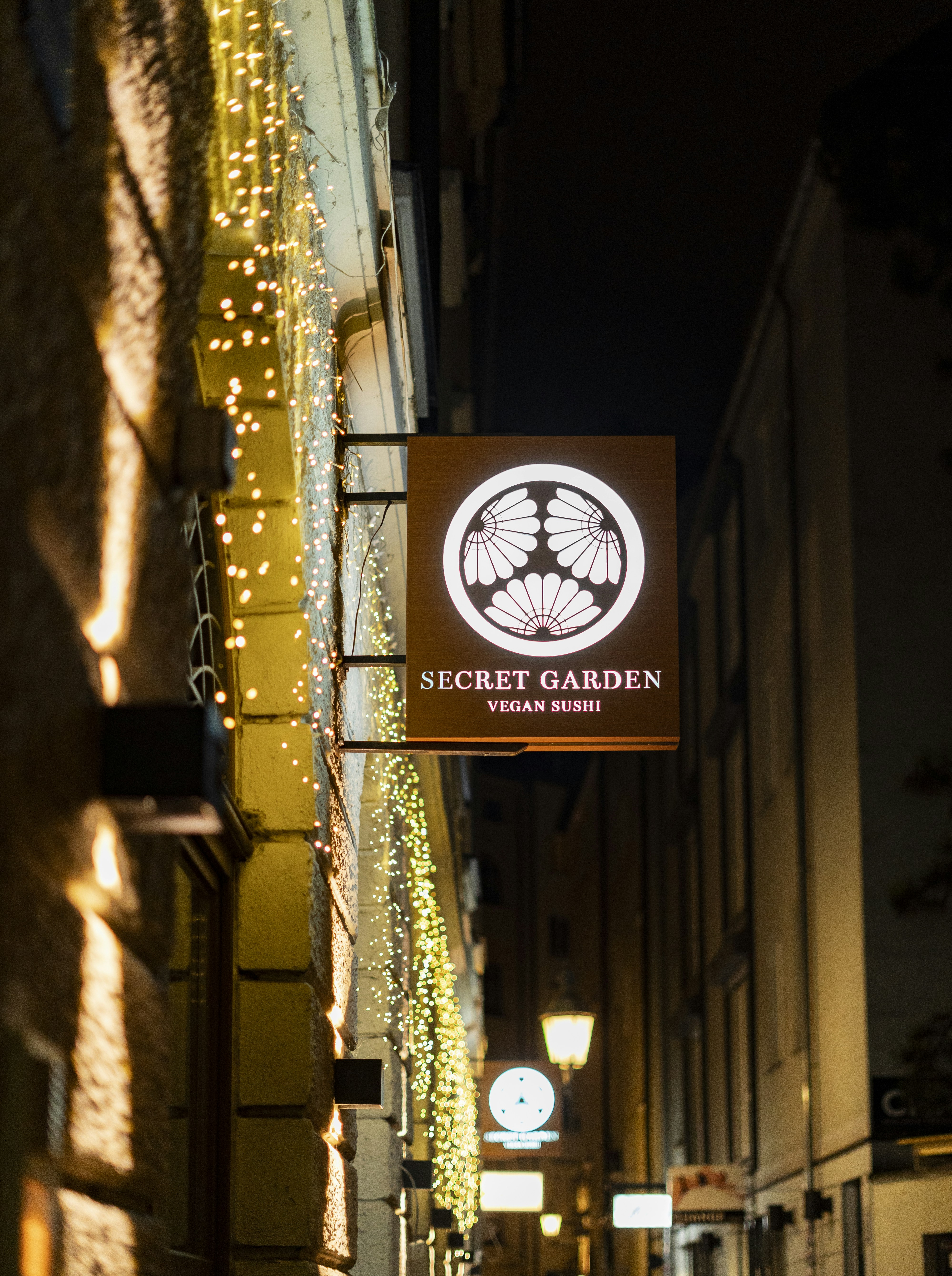 Secret garden vegan sushi restaurant sign at night.