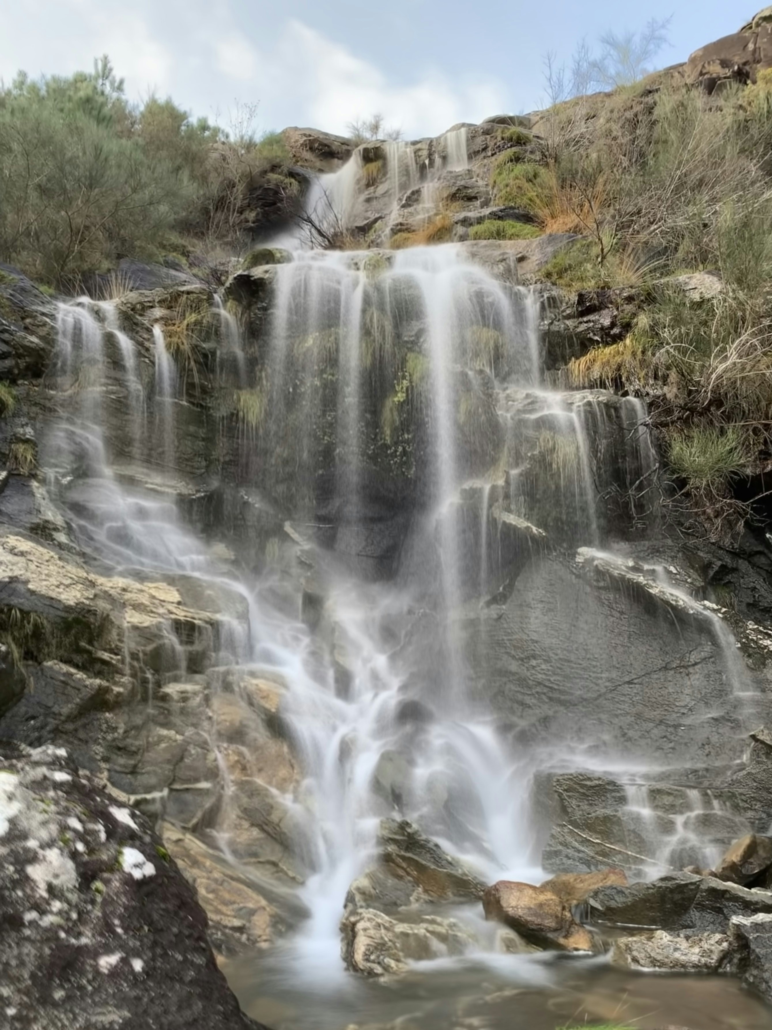 A beautiful waterfall cascades down rocky terrain.