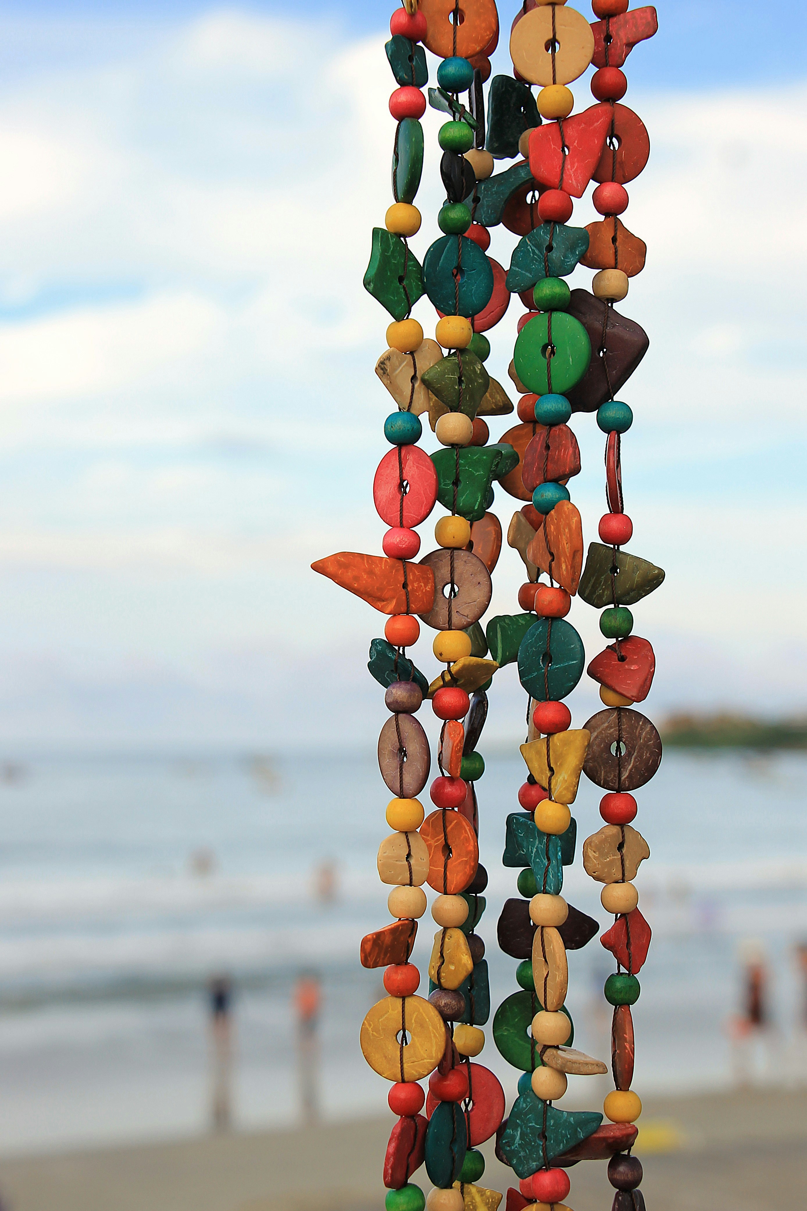 Colorful beaded garland hangs with ocean background