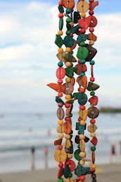 Colorful beaded garland hangs with ocean background